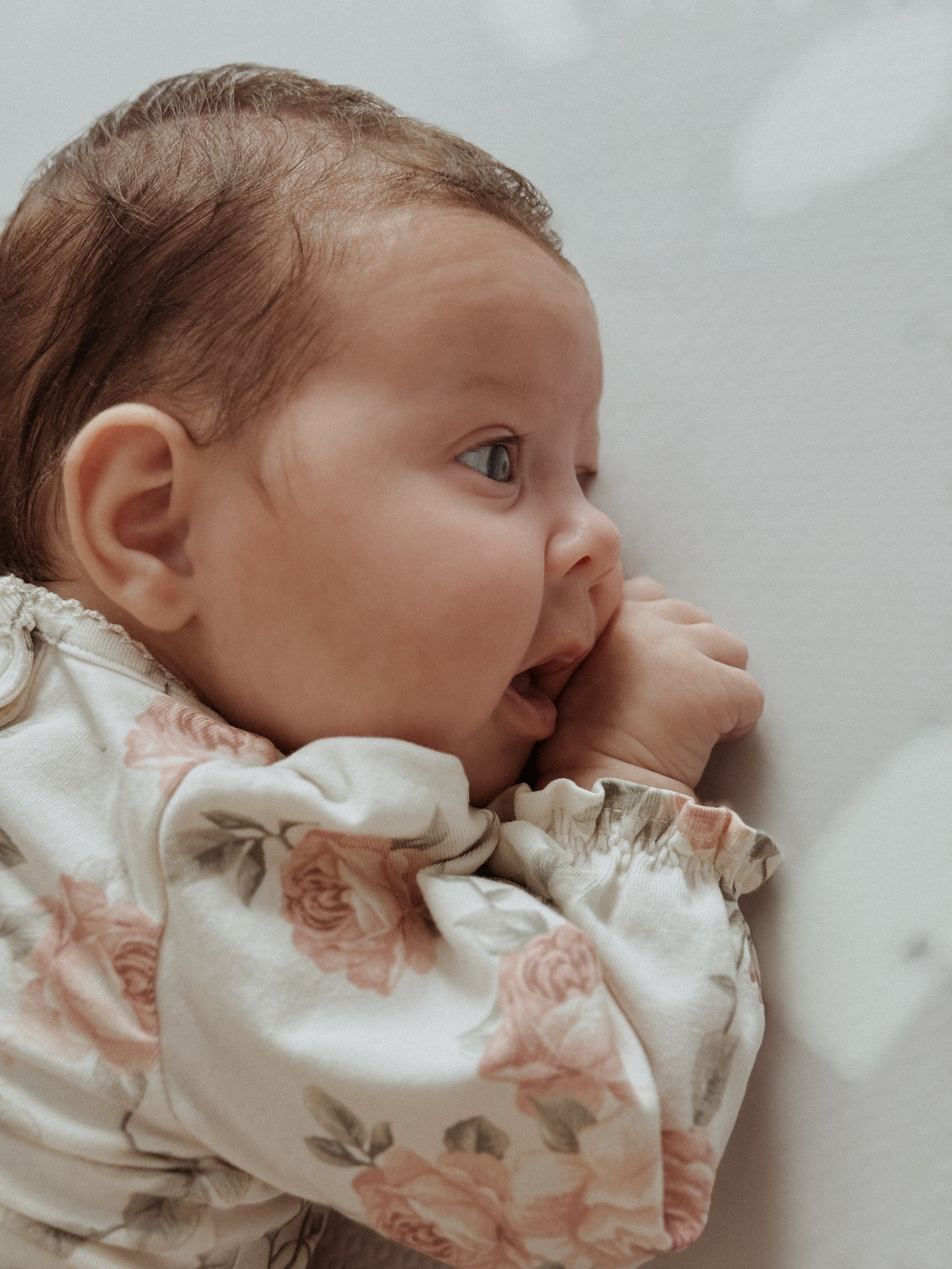 a baby giggling on a soft lavender terrazzo foam mat during playtime