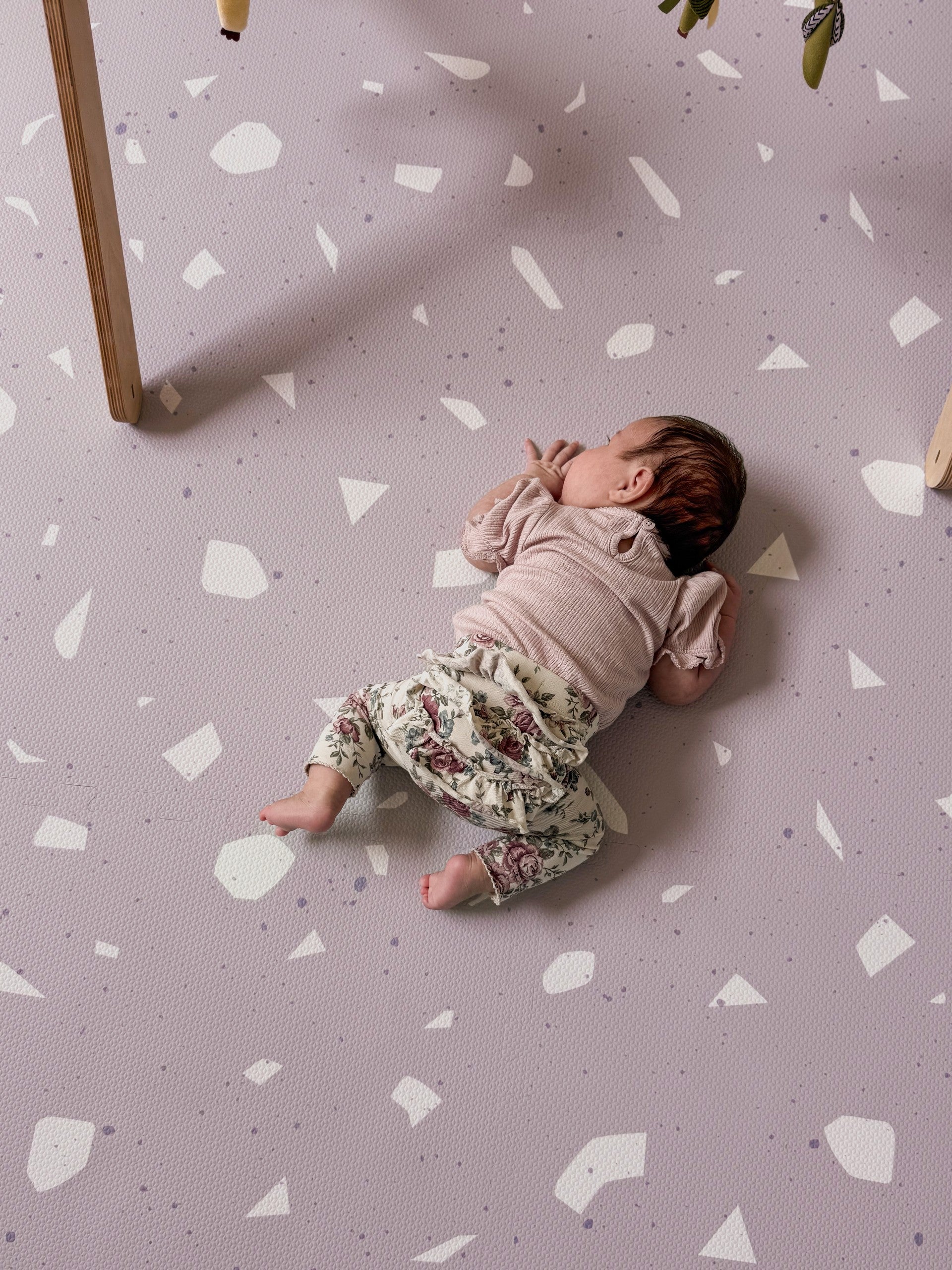a soft lavender terrazzo foam playmat bathed in gentle morning light