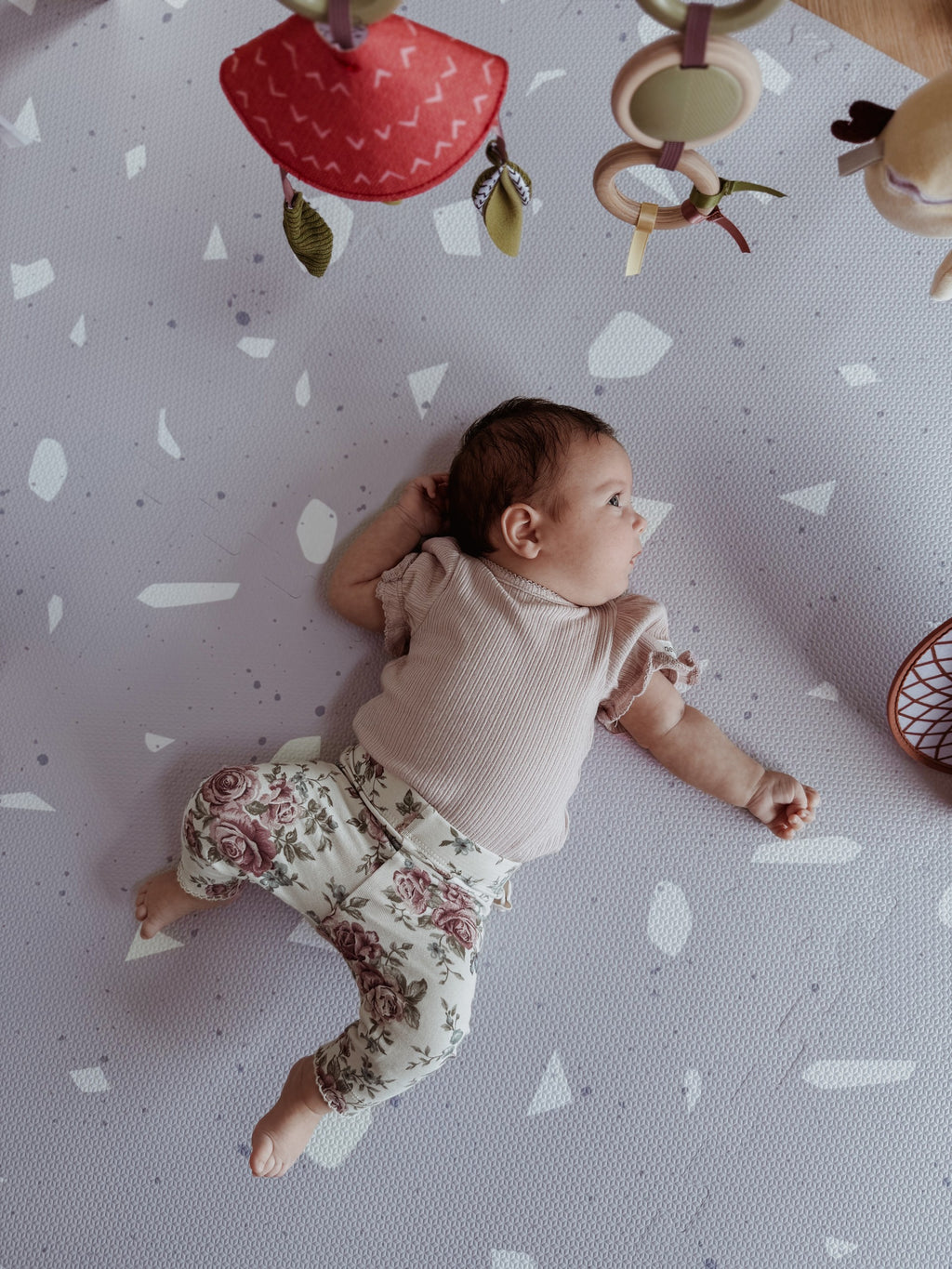 bold lavender terrazzo foam playmat for babies in dramatic studio lighting