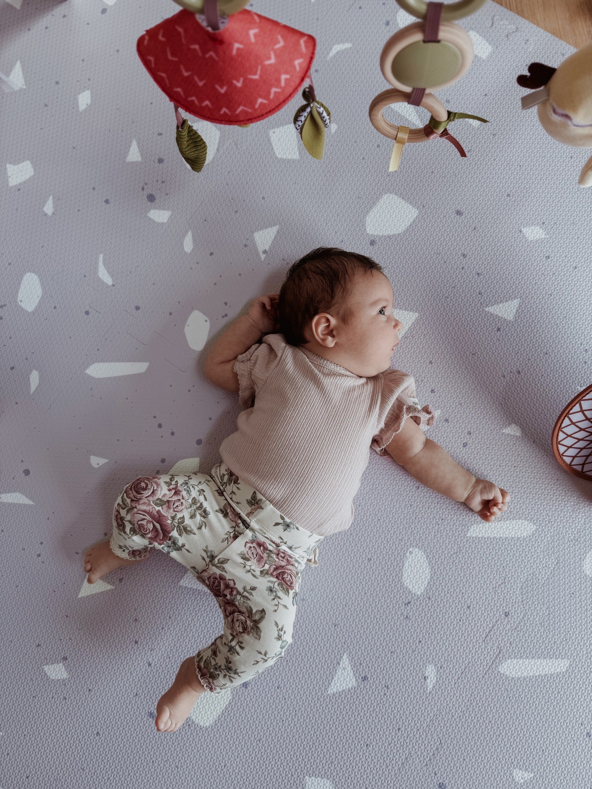 bold lavender terrazzo foam playmat for babies in dramatic studio lighting