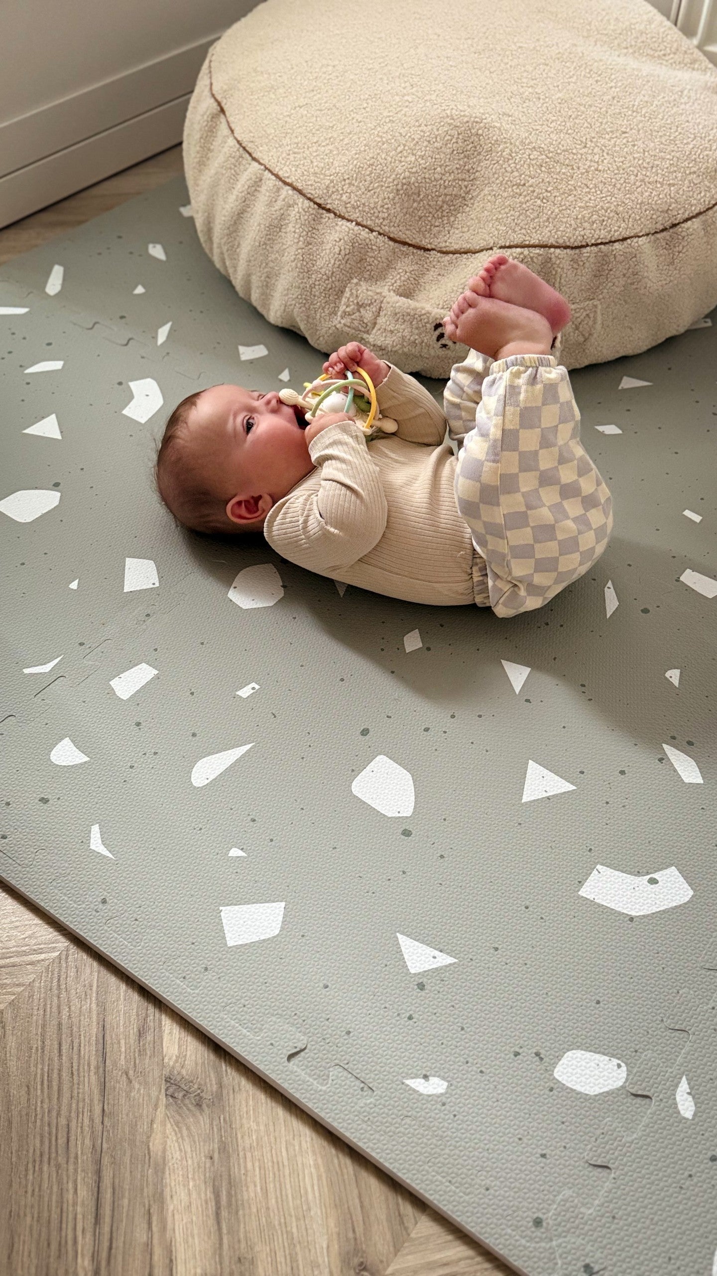 a soft sage terrazzo baby playmat on a cozy nursery floor in gentle morning light