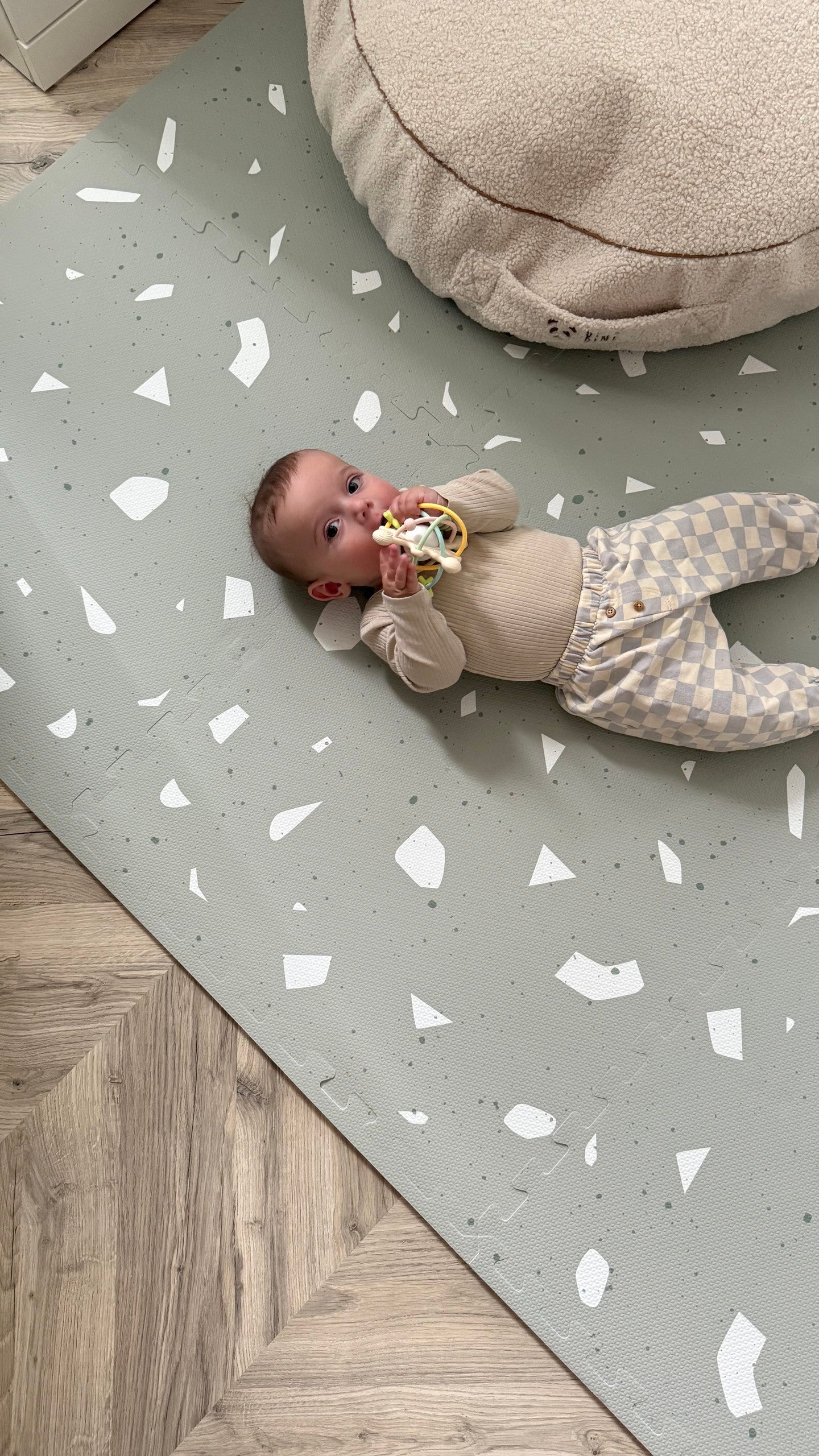 a sage terrazzo foam playmat tile in elegant morning light, showcasing its refined pattern and soft texture