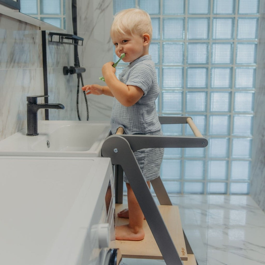 a child's hands kneading dough on the foldable kitchen helper tower's platform