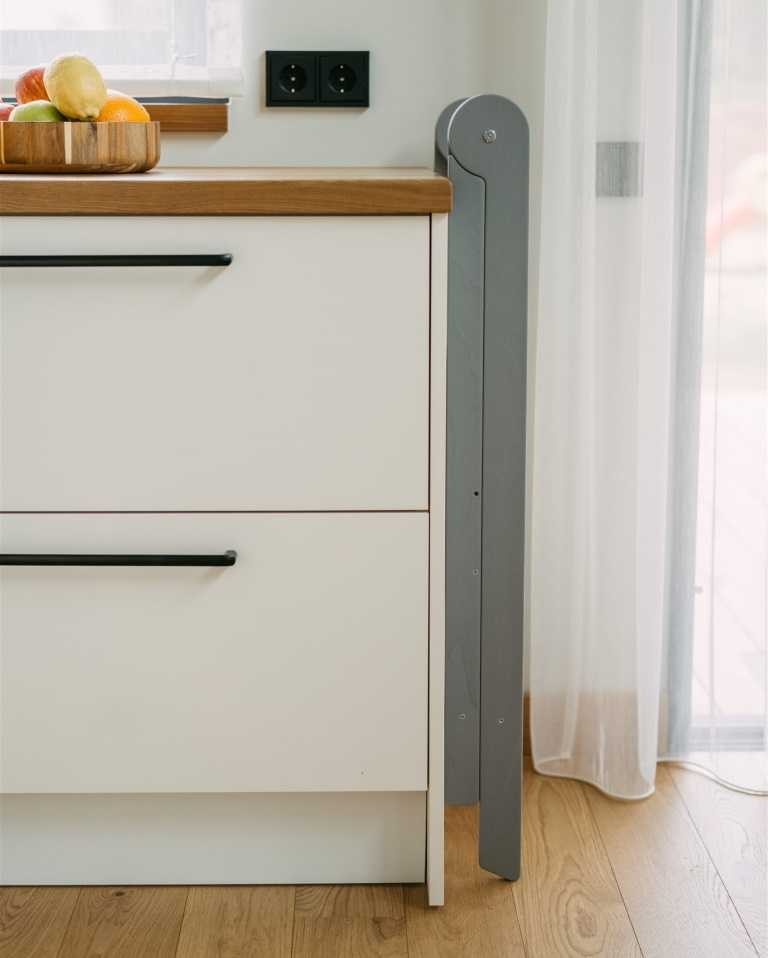 foldable kitchen helper tower in a bright, airy nursery with morning light