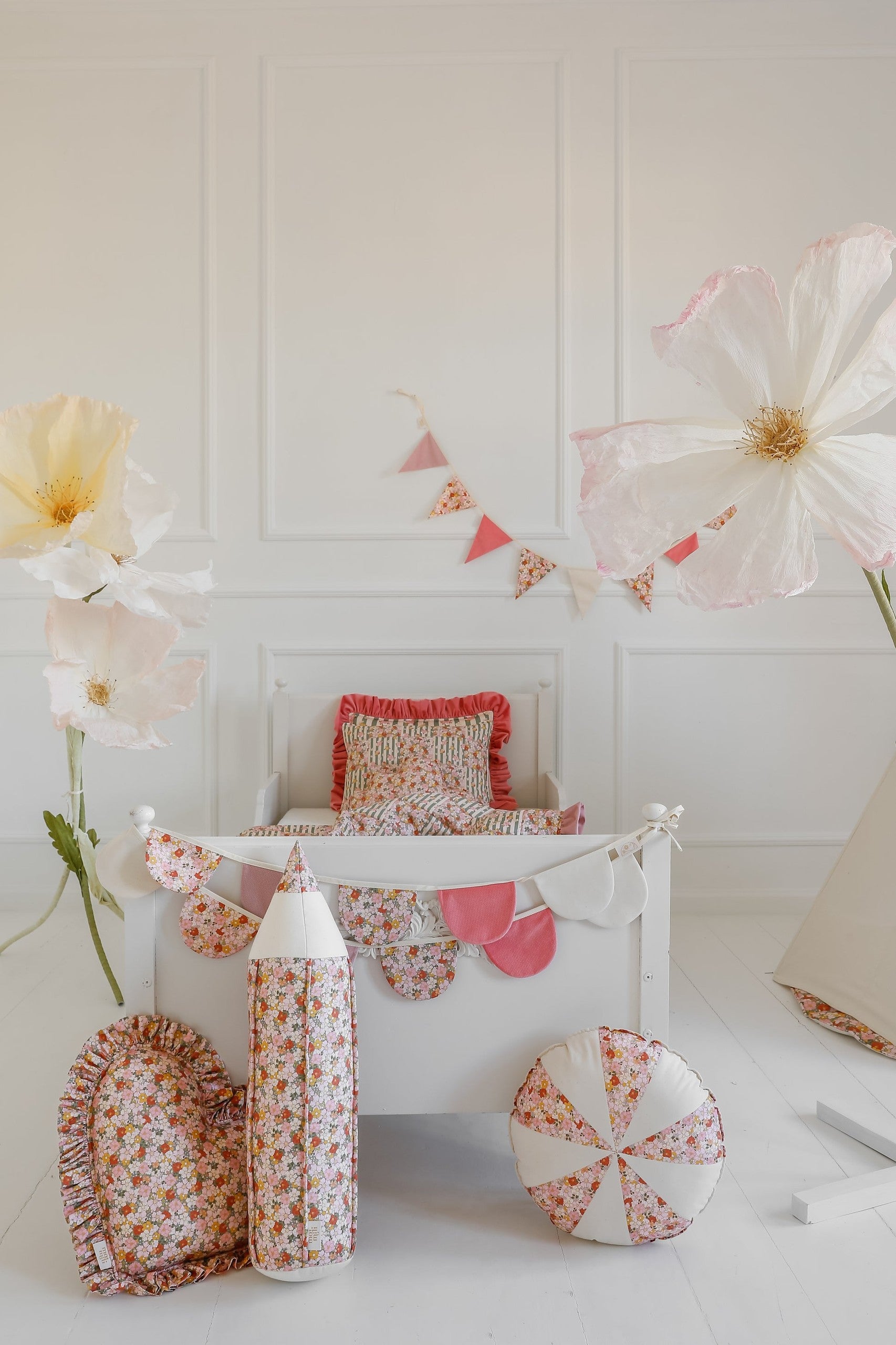 playful cotton and velvet birthday garland hung over a cozy teepee tent for a magical kids room