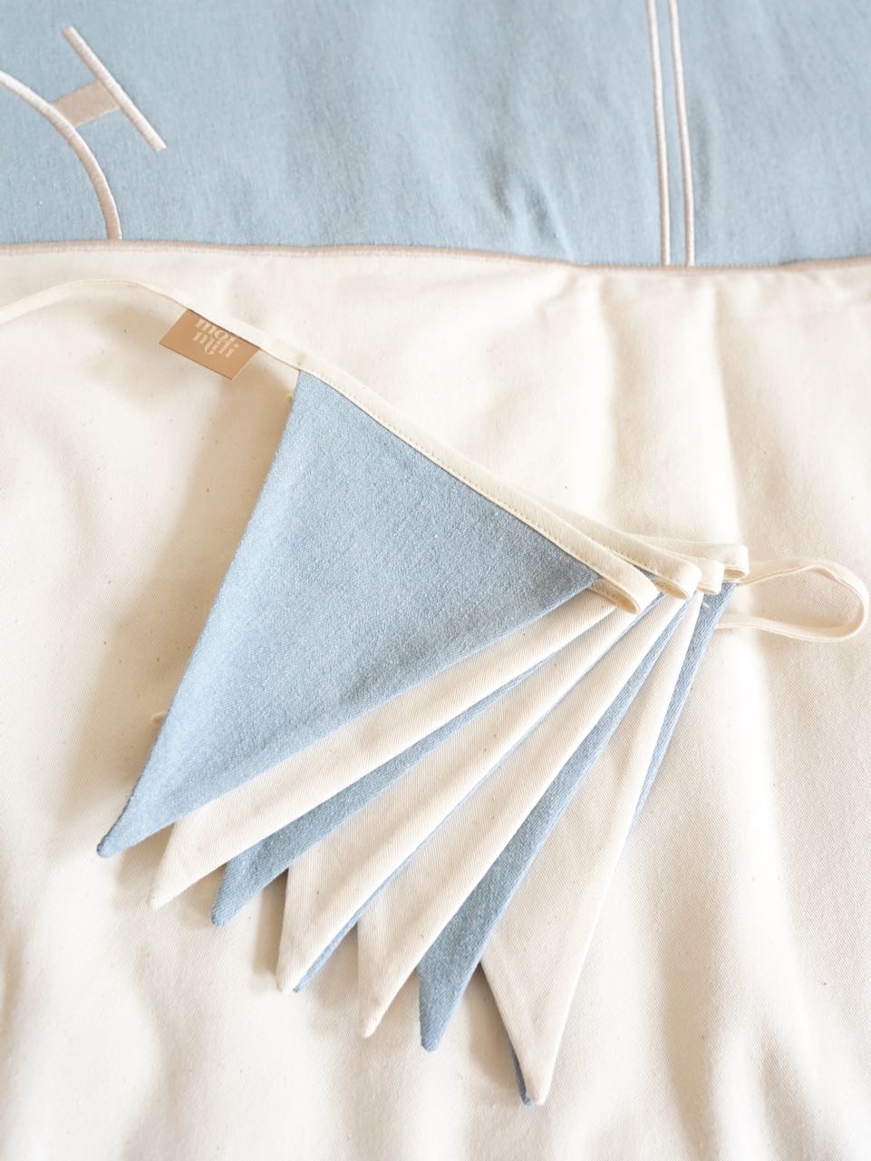 soft cotton and linen garland with 9 charming pendants, draped gently over a wooden crib for a cozy nursery touch