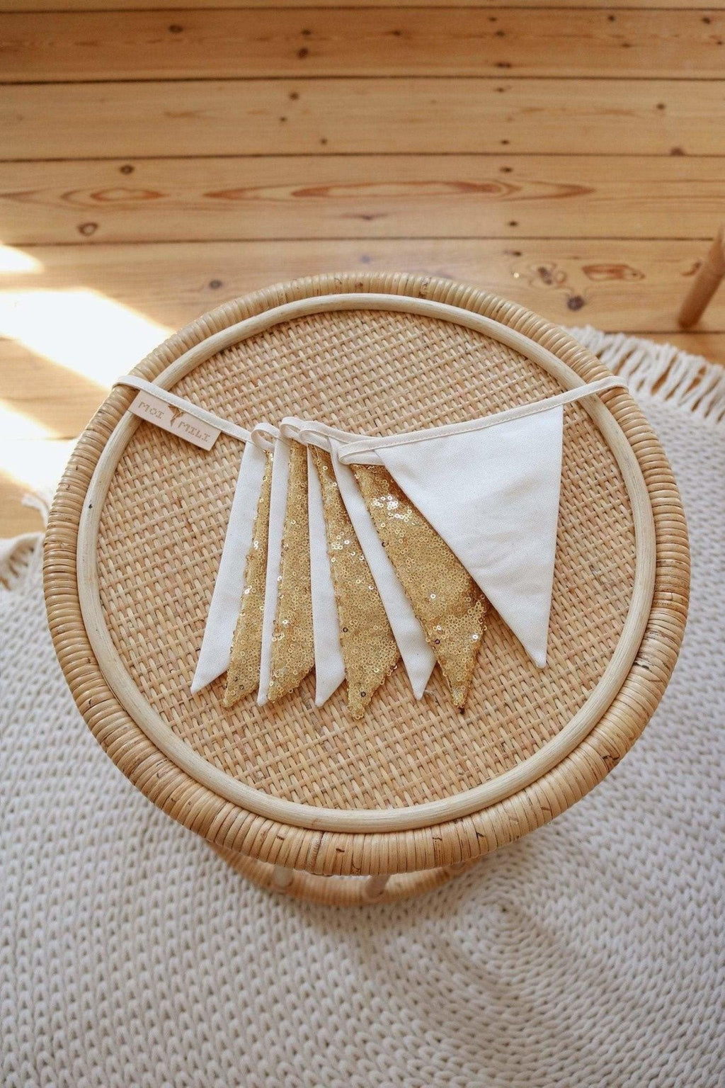soft gold and beige sequin garland draped gently over a wooden crib, creating a cozy nursery ambiance