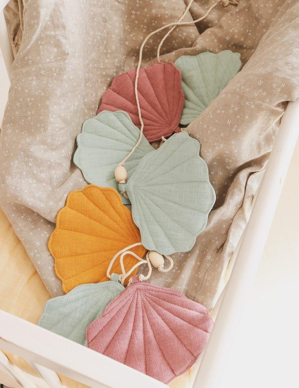 playful kids shell garland with mango and pink shells on a sunny windowsill