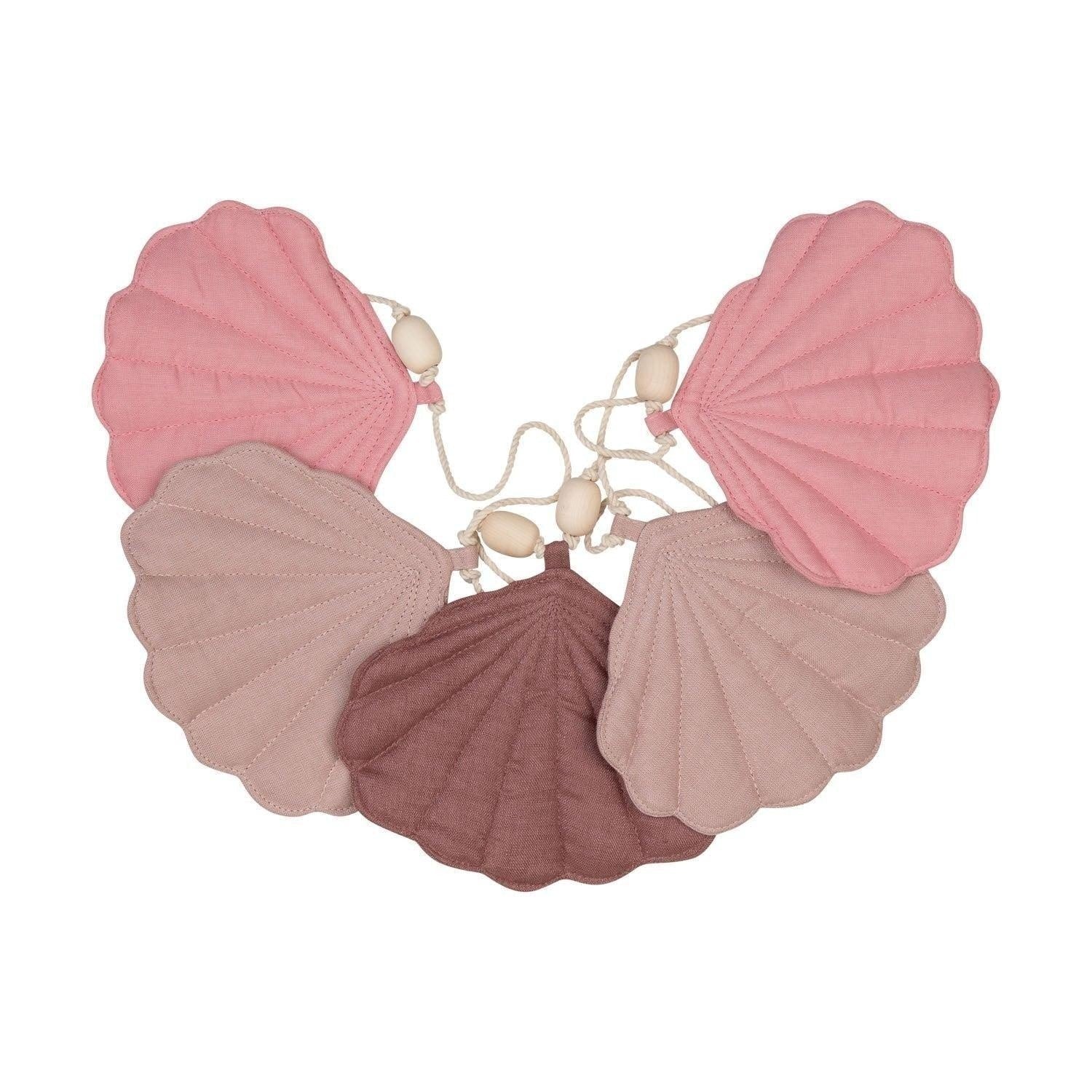 powder pink shell garland playfully draped over a childs reading nook with wooden beads