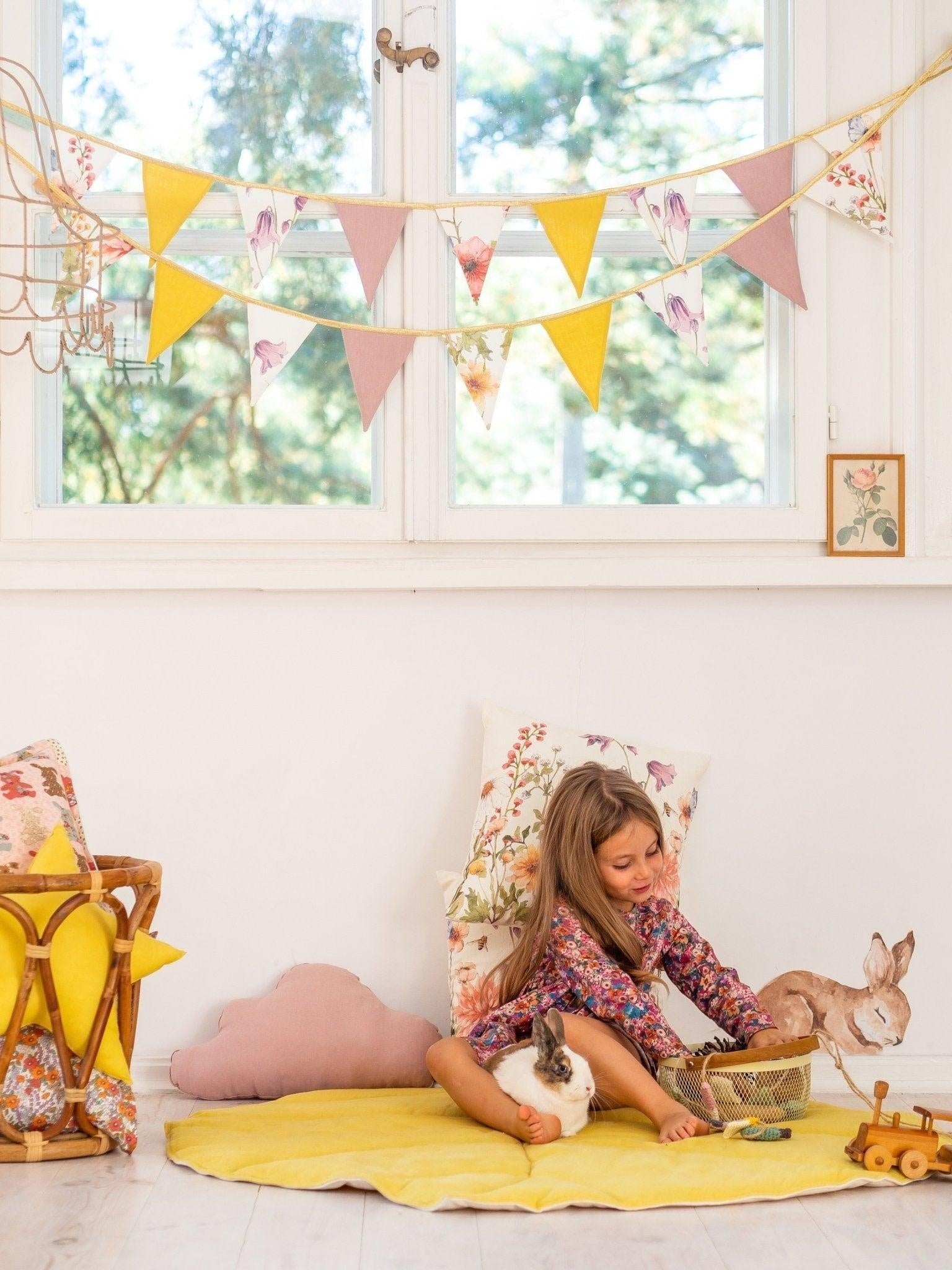bold wildflower garland draped over a rustic wooden crib in dramatic morning light