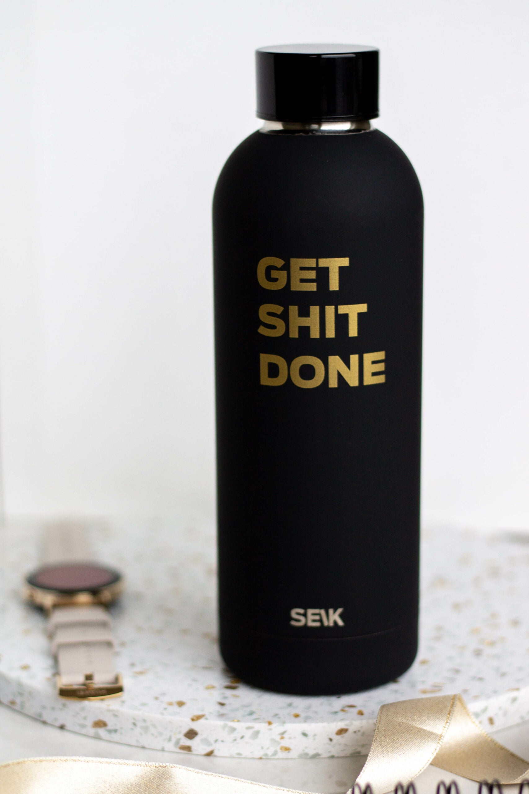 a playful black seik water bottle on a sunny park bench ready for adventure