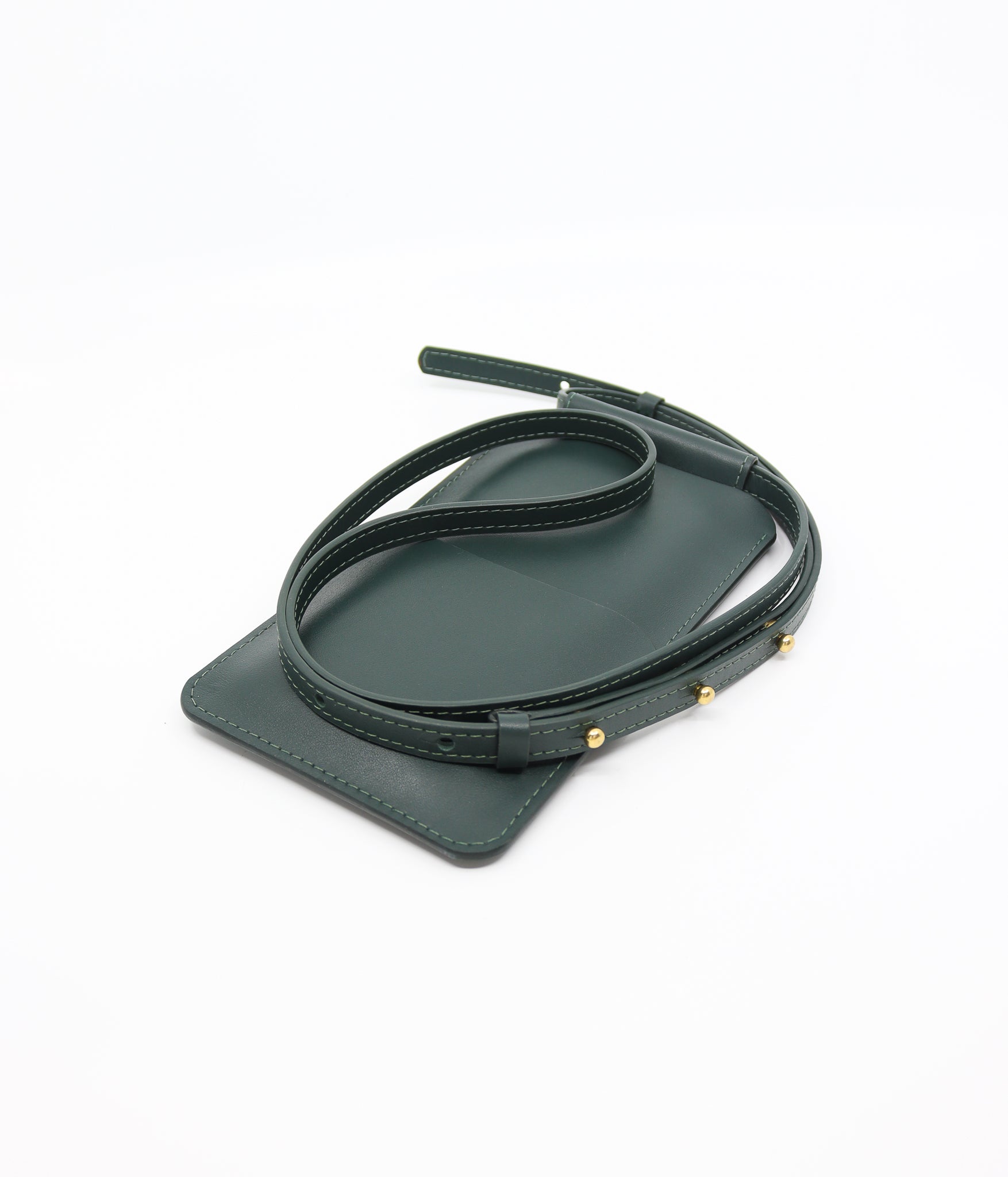 playful forest green leather crossbody phone bag on a sunny park bench