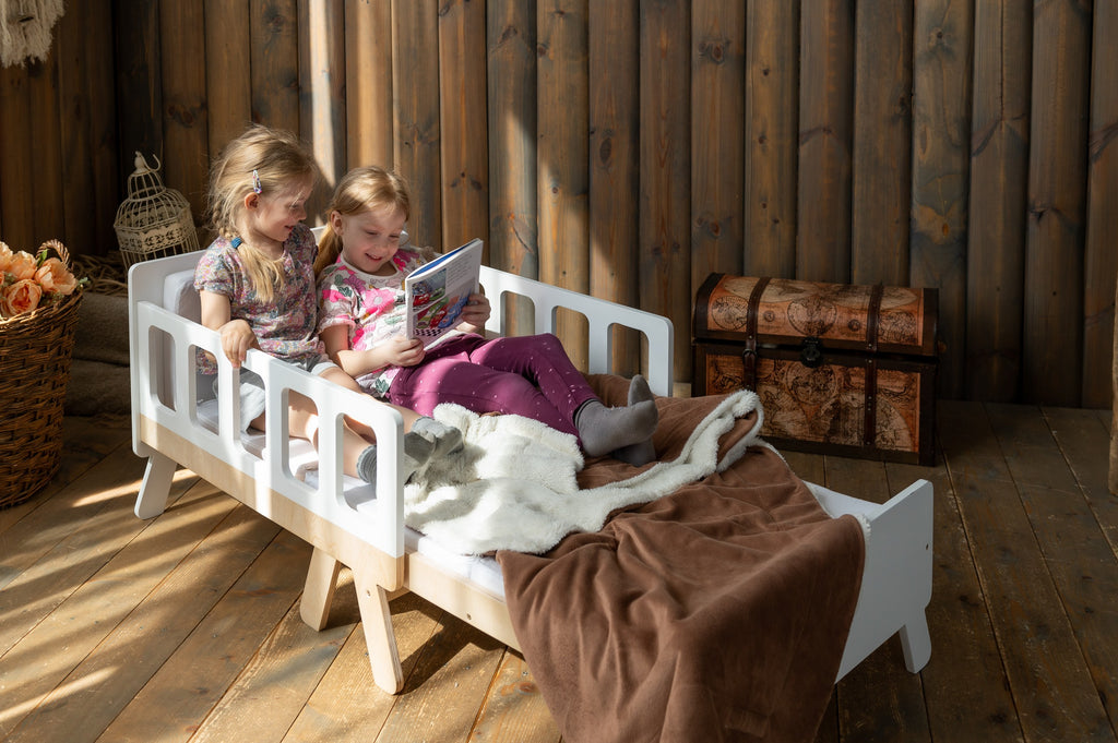 a child reading on the growing bed transformed into a cozy sofa with armrests