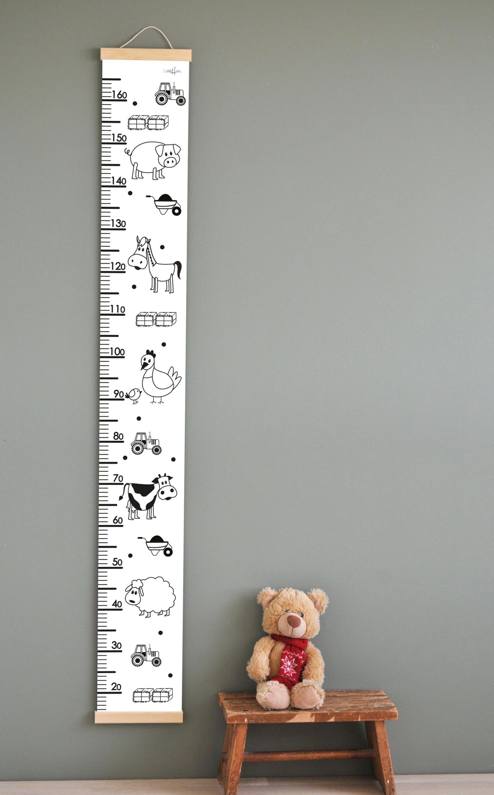 confident front view of the delightful farm animal growth chart hanging on a bright nursery wall