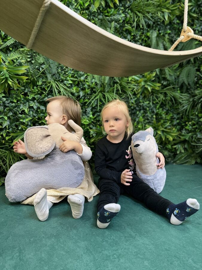 a soft grey handmade wolf pillow toy resting on a cozy blanket, perfect for a child's nap