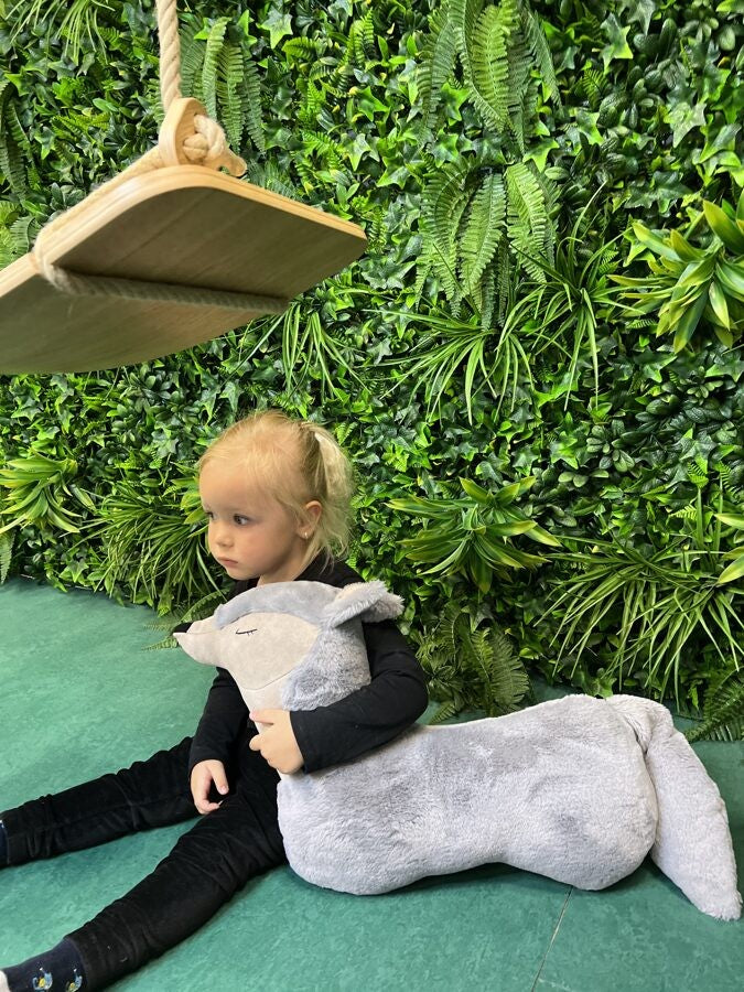 a bold handmade grey wolf pillow toy in dramatic low-angle studio lighting