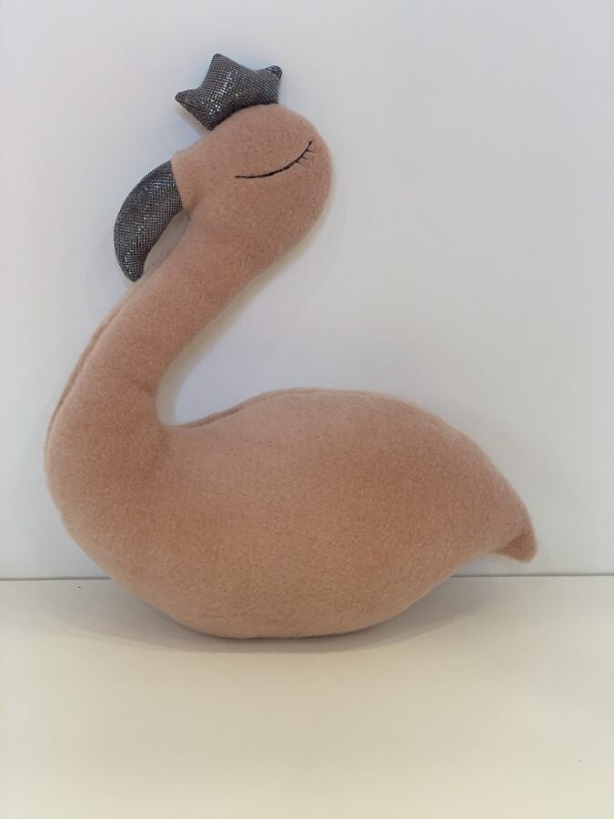 handmade llama wool flamingo soft toy with a felt crown on a neutral nursery shelf