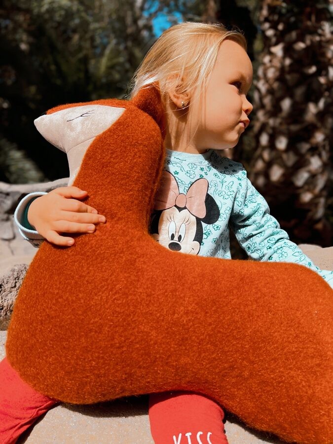 a handmade forest fox red cuddle pillow for kids, shown in soft morning light on a cozy blanket