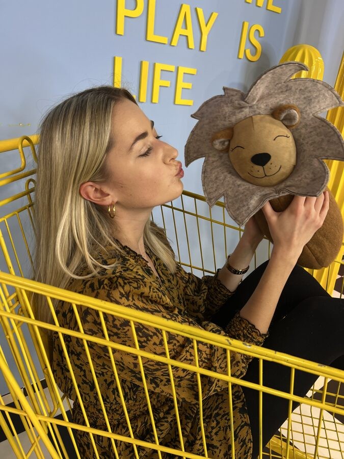 handmade lion cuddle pillow in a playful mid-roar pose on a bright nursery floor