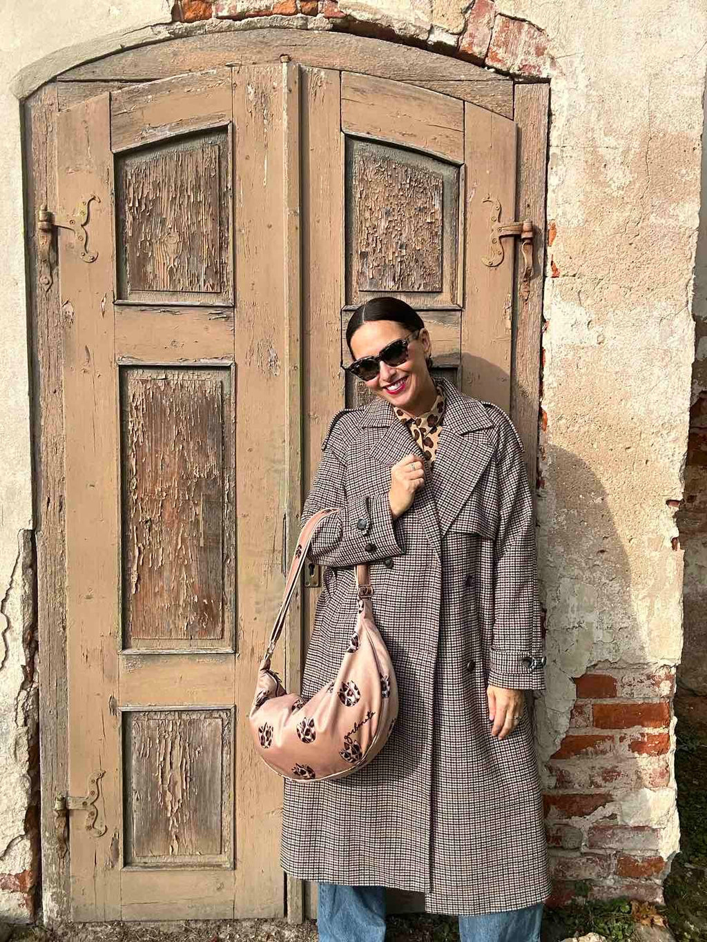 playful brown leopard tulip hobo bag in warm sunlight, showing its soft velour texture and slouchy shape