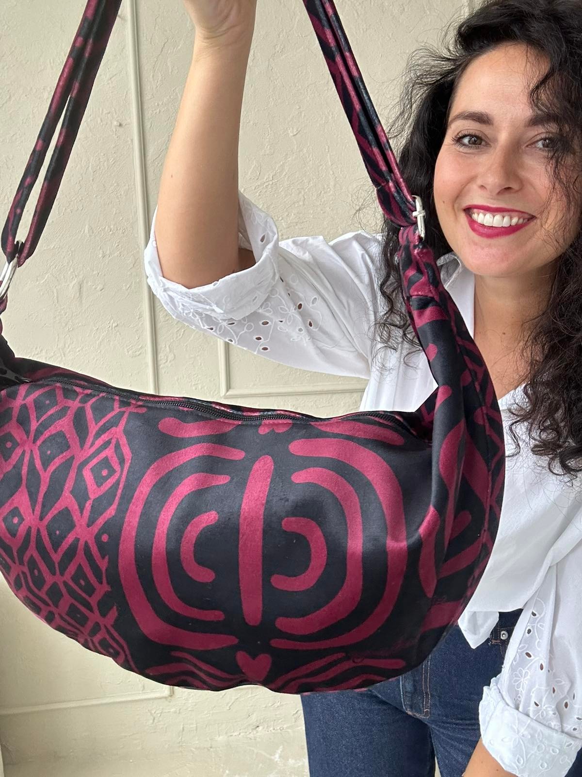 playful burgundy velour hobo bag with a long adjustable strap, shown in warm golden hour light
