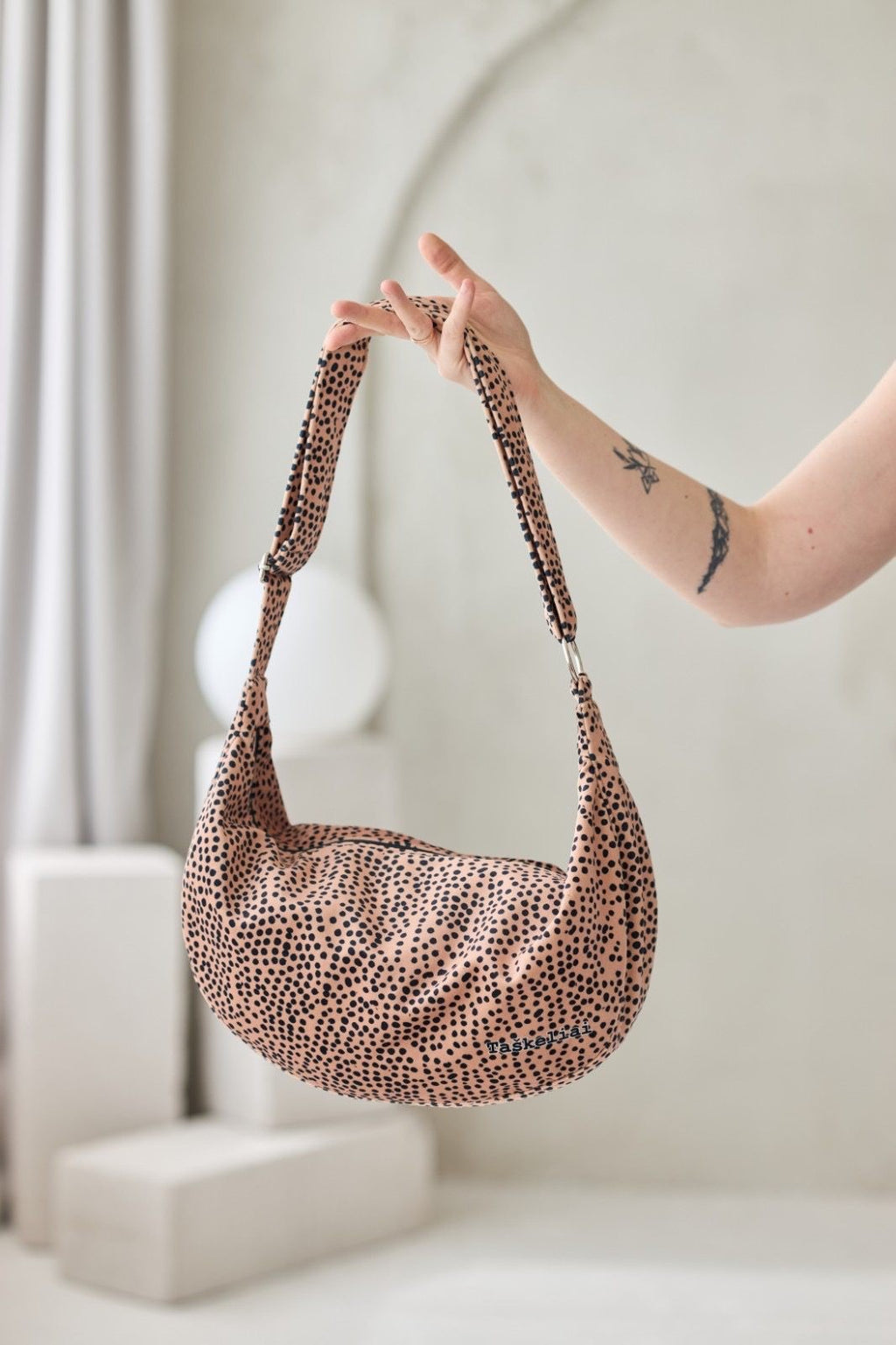 bold statement hobo bag in cream with chic black dots, shown from a powerful front angle