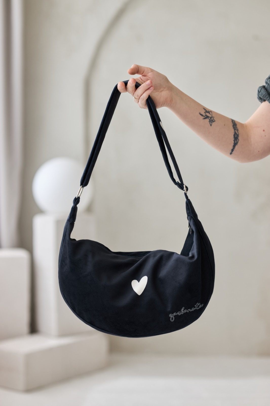 elegant black velour hobo bag with a refined slouch, showcasing its adjustable crossbody strap
