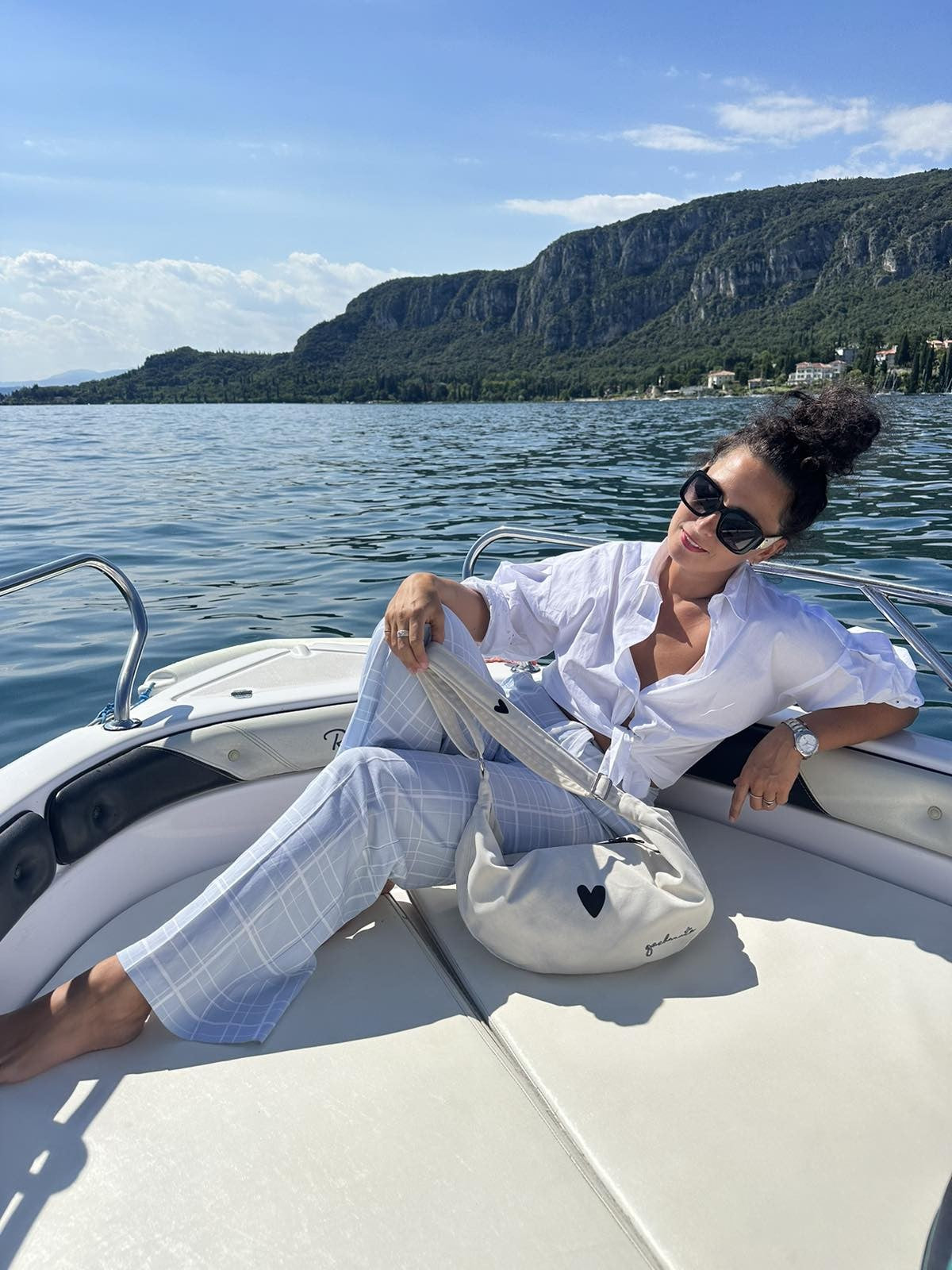 elegant white velour hobo bag with heart charm on a soft linen background