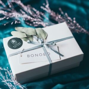 a soft cotton baby gift box with juniper candle and orange cream in warm light