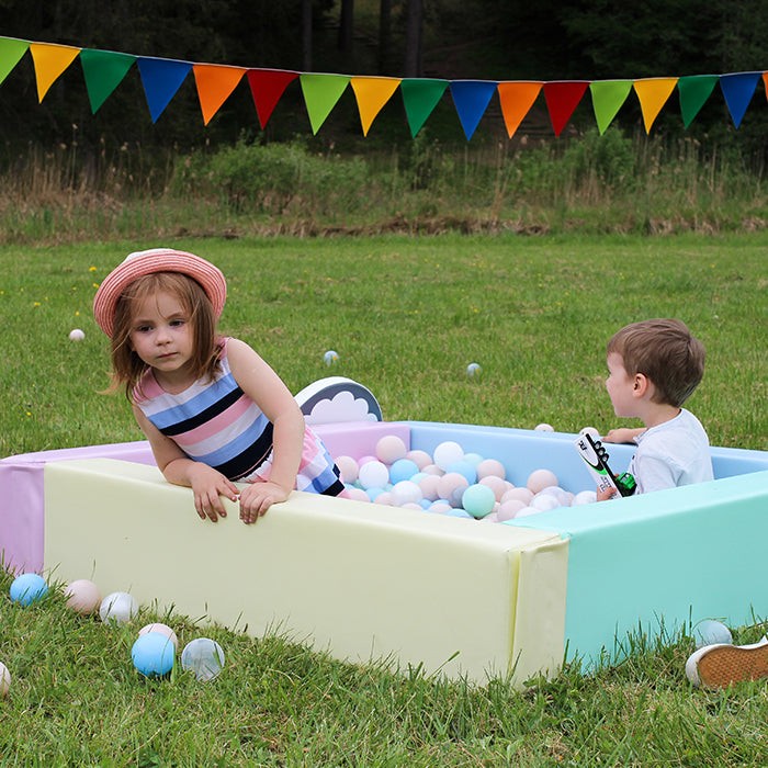 a soft pastel ball pit for toddlers with a gentle low-profile entrance in a cozy nursery