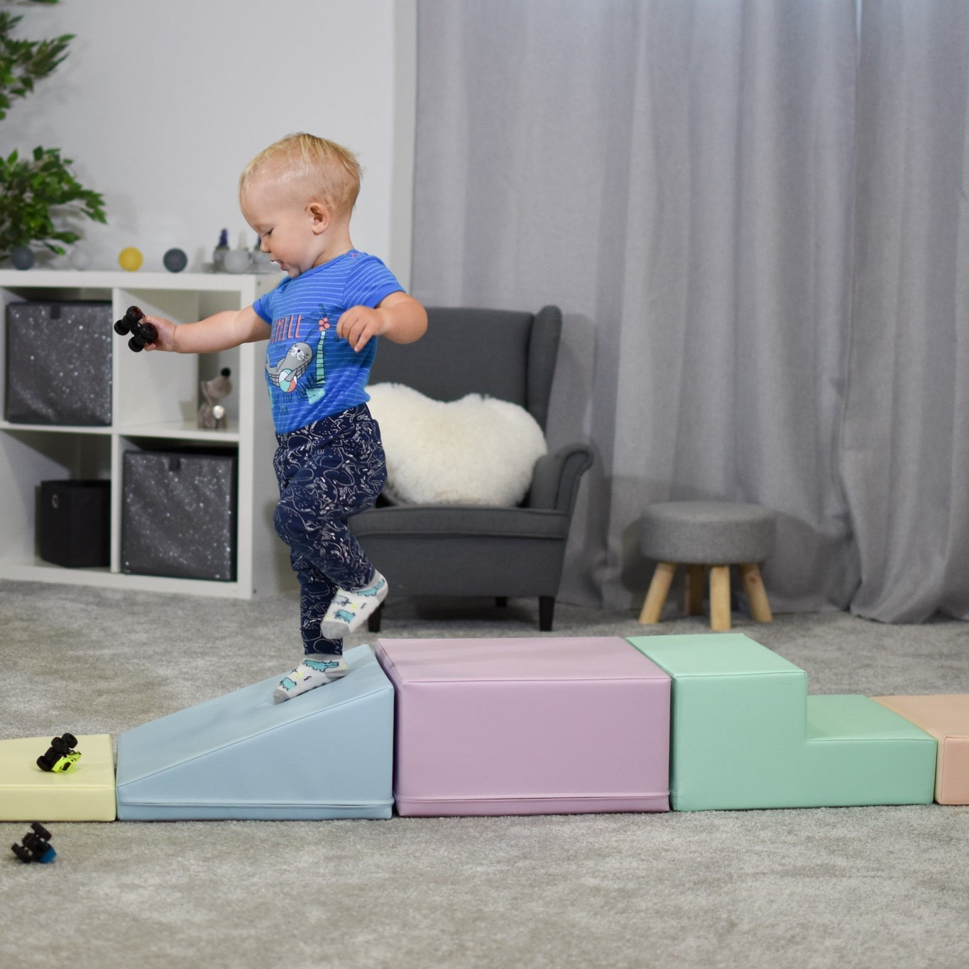 a toddler climbing on a soft pastel foam block climber in a sunlit playroom