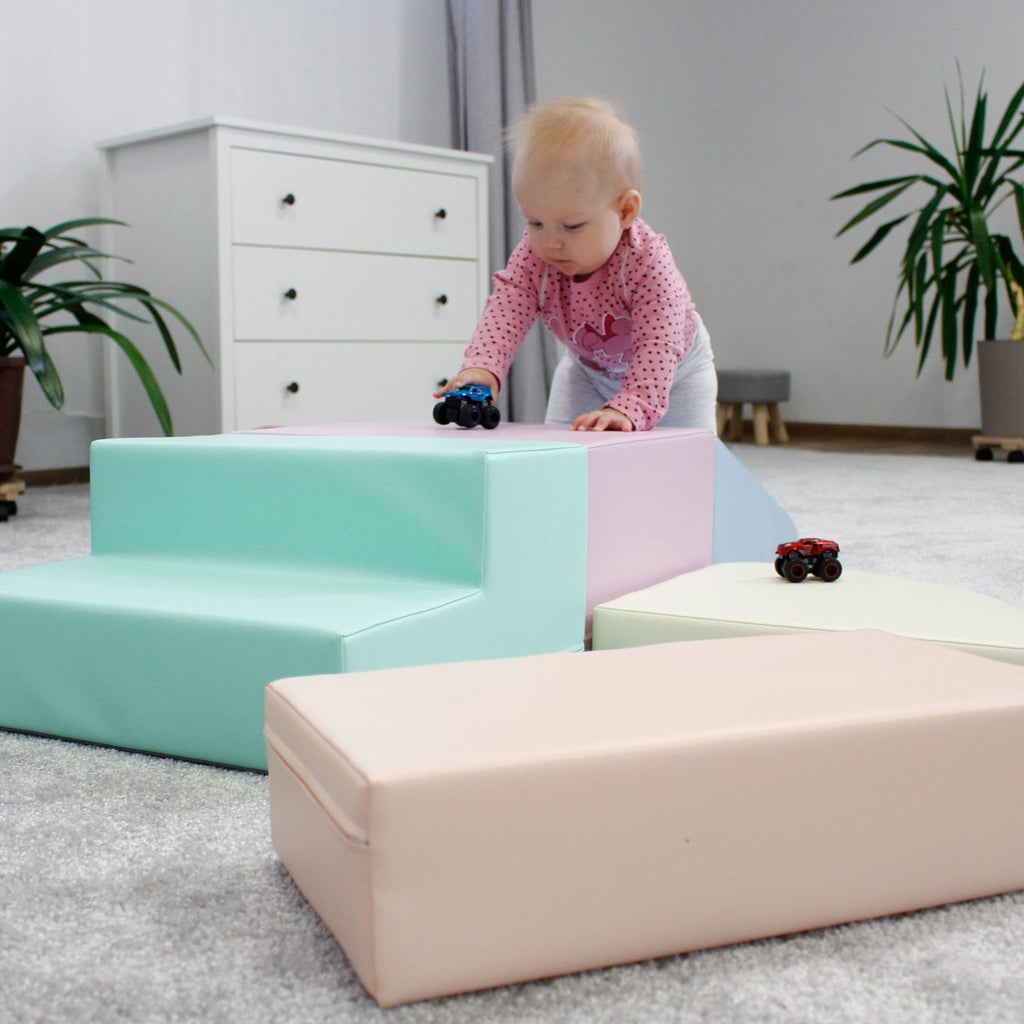 a toddler climbing on a soft pastel foam block corner climber in a sunlit playroom