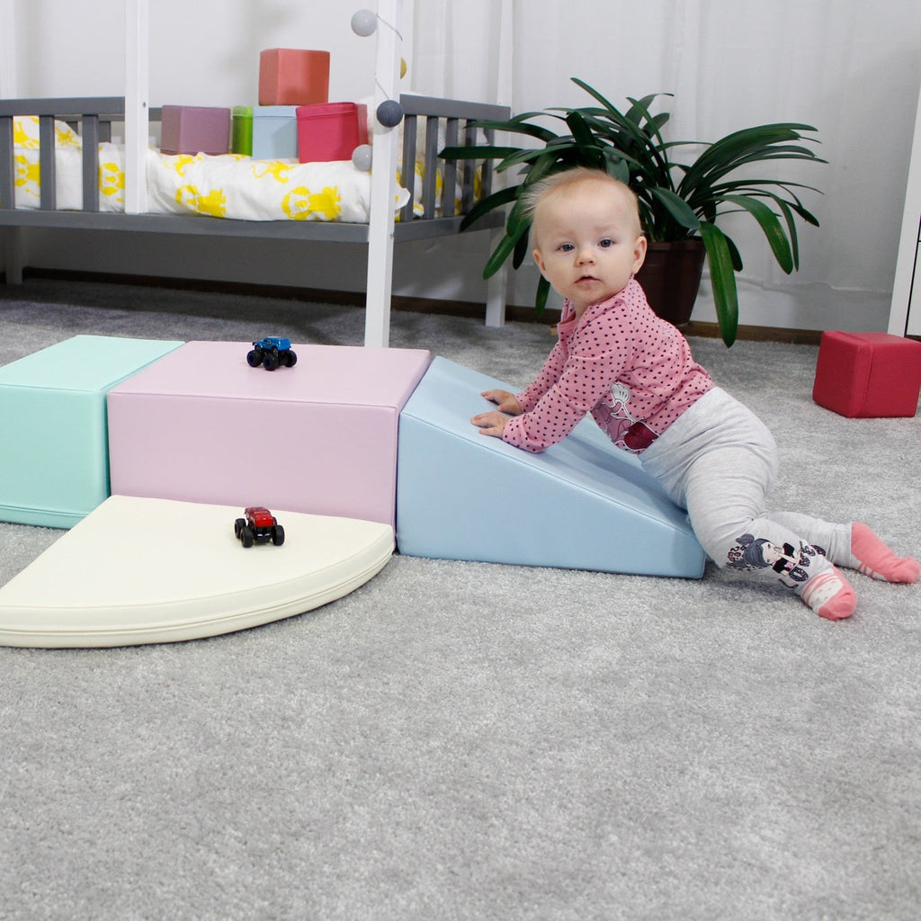 a toddler climbing on a soft pastel foam block corner climber in a bright playroom