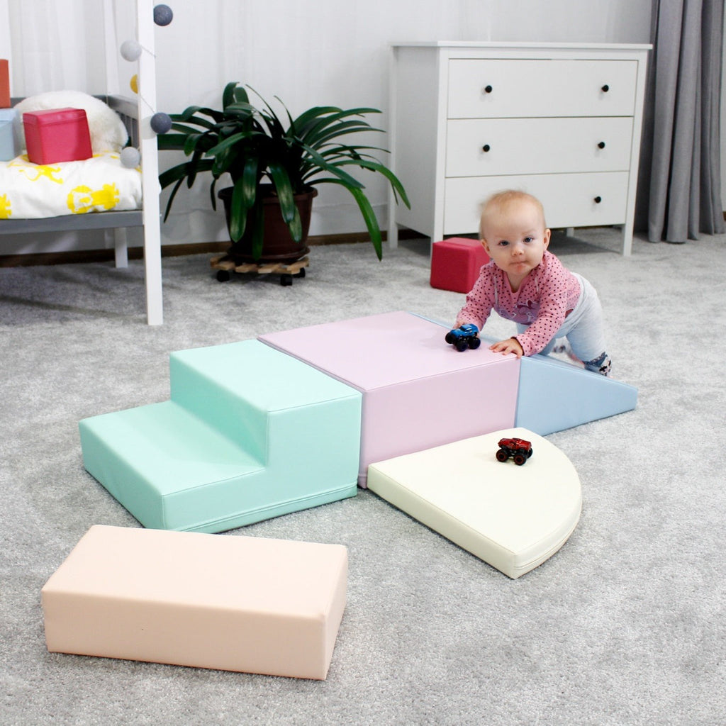 toddler climbing on a pastel foam corner climber in a sunlit playroom
