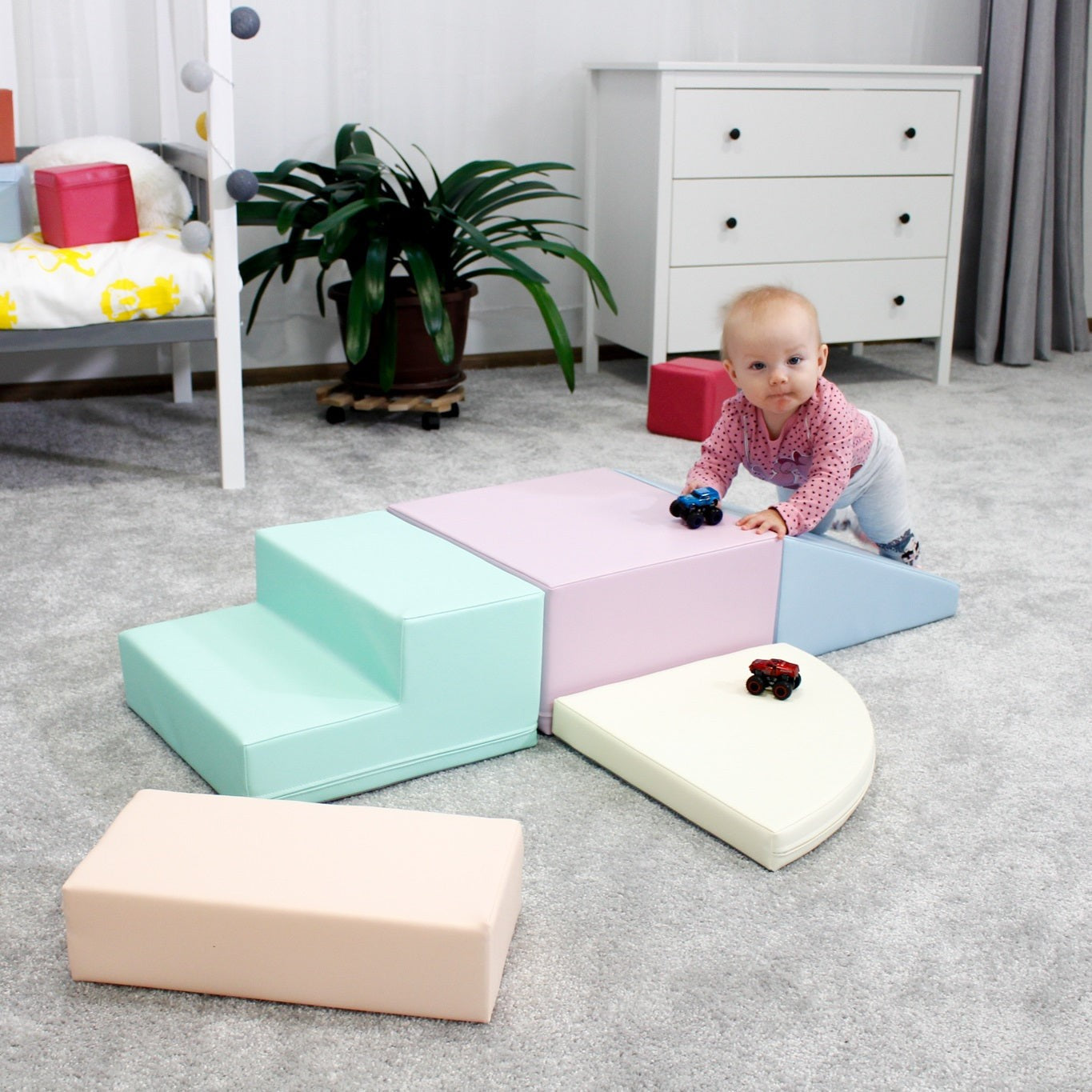toddler climbing on a pastel foam corner climber in a sunlit playroom