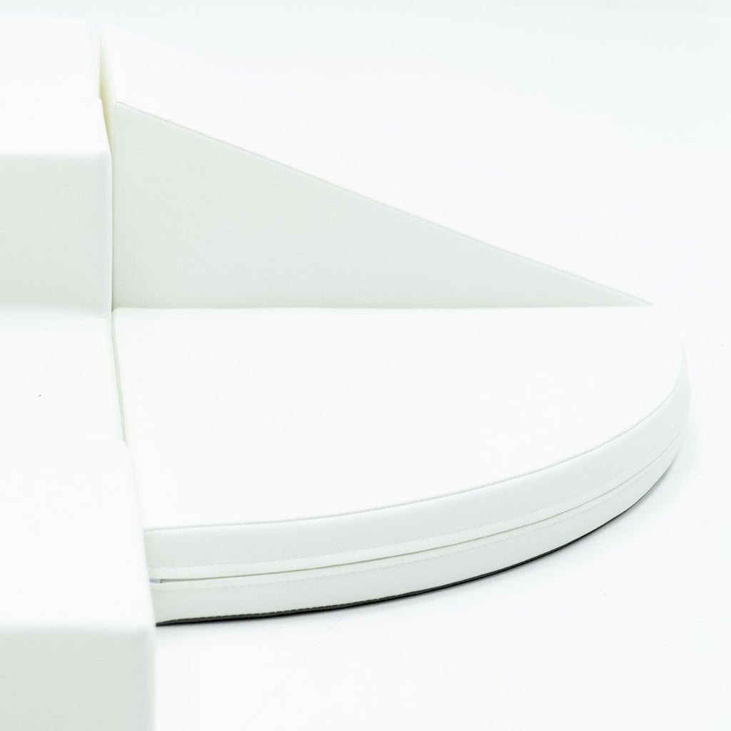 a child's hand reaching for a soft white corner climber foam block