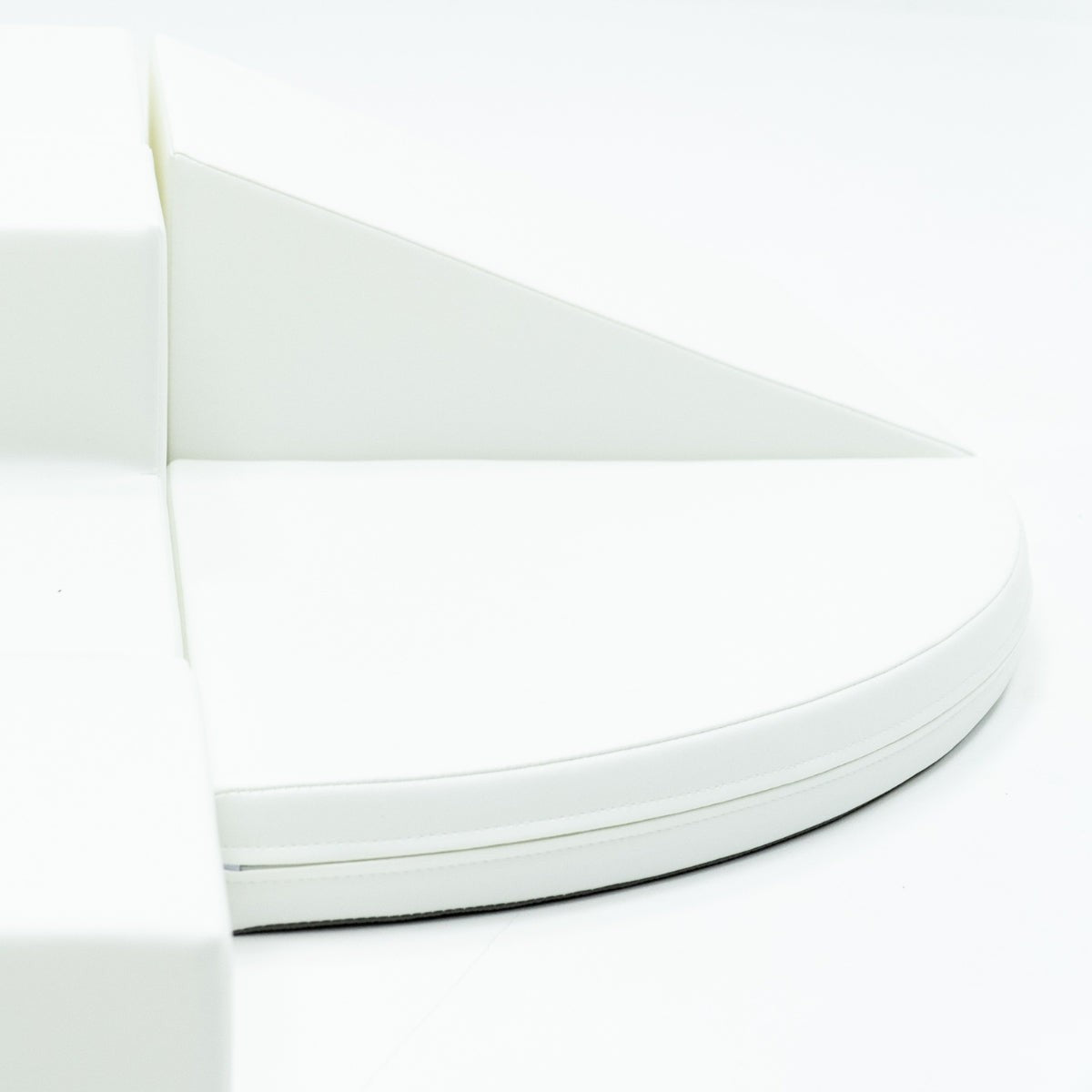 a child's hand reaching for a soft white corner climber foam block