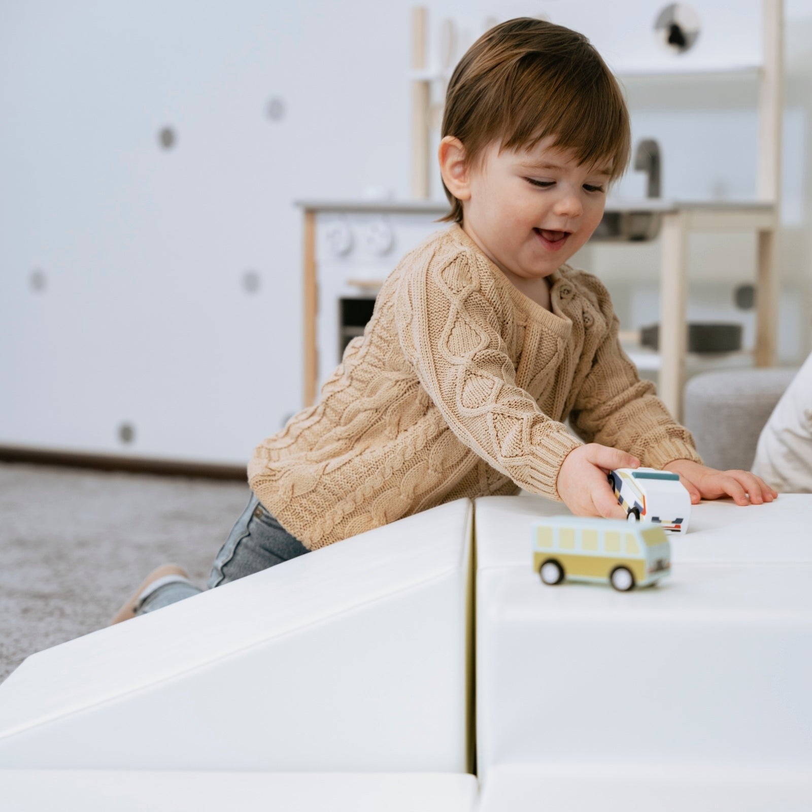 white foam corner climber block in a bright, airy playroom setting