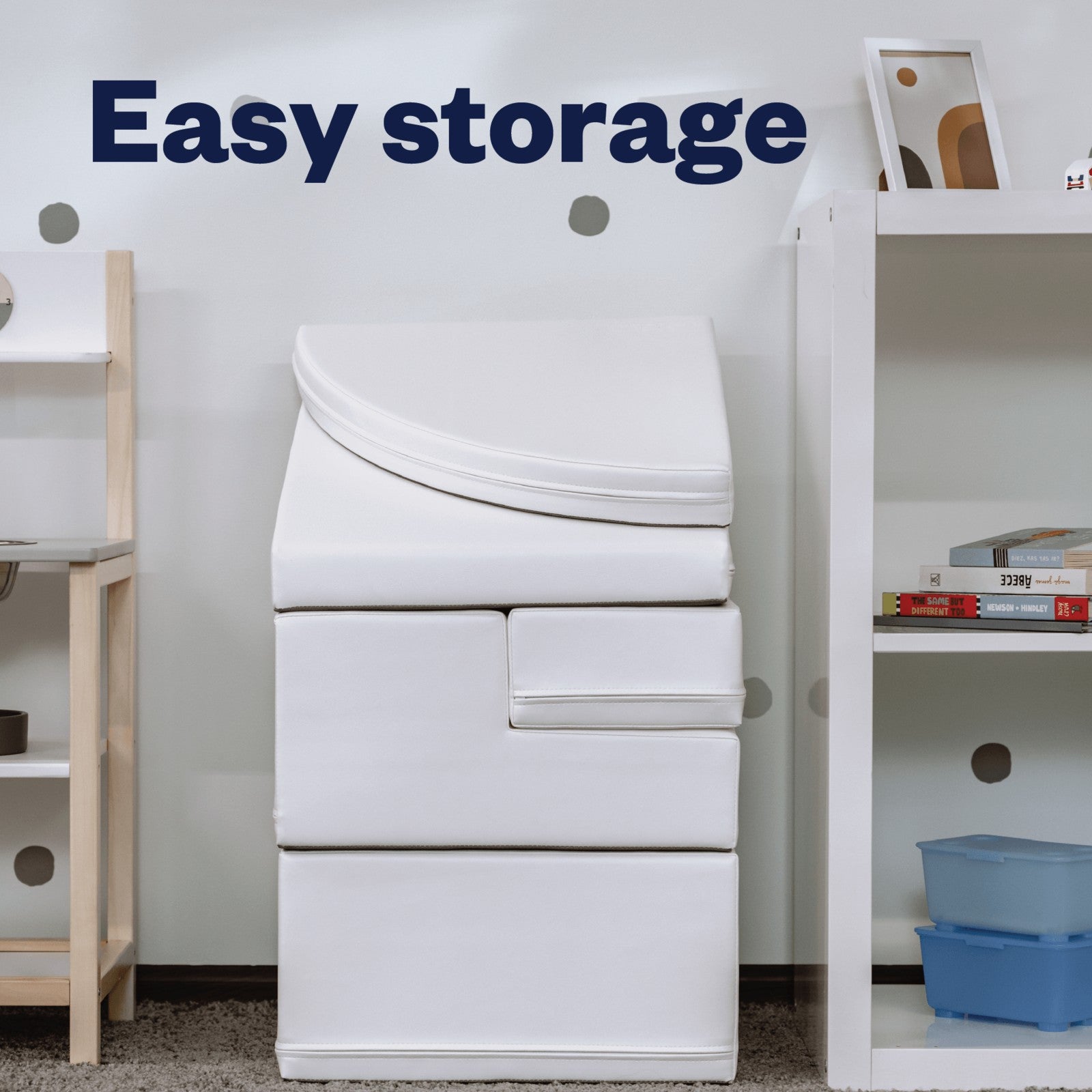 a child's hand reaching for the top of a soft white corner climber foam block