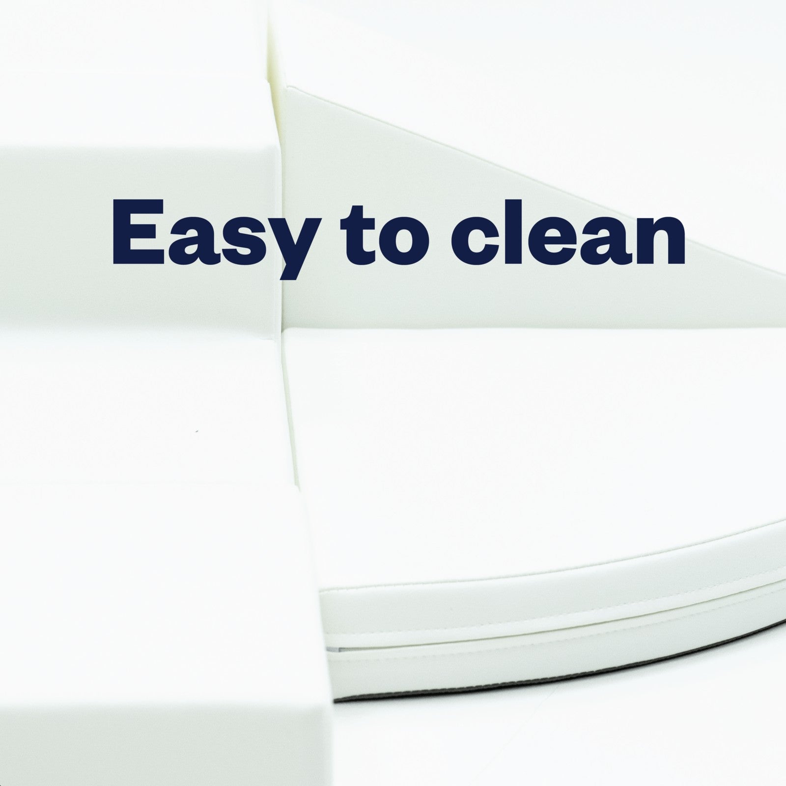 a toddler climbing on a soft white foam corner climber in a bright playroom