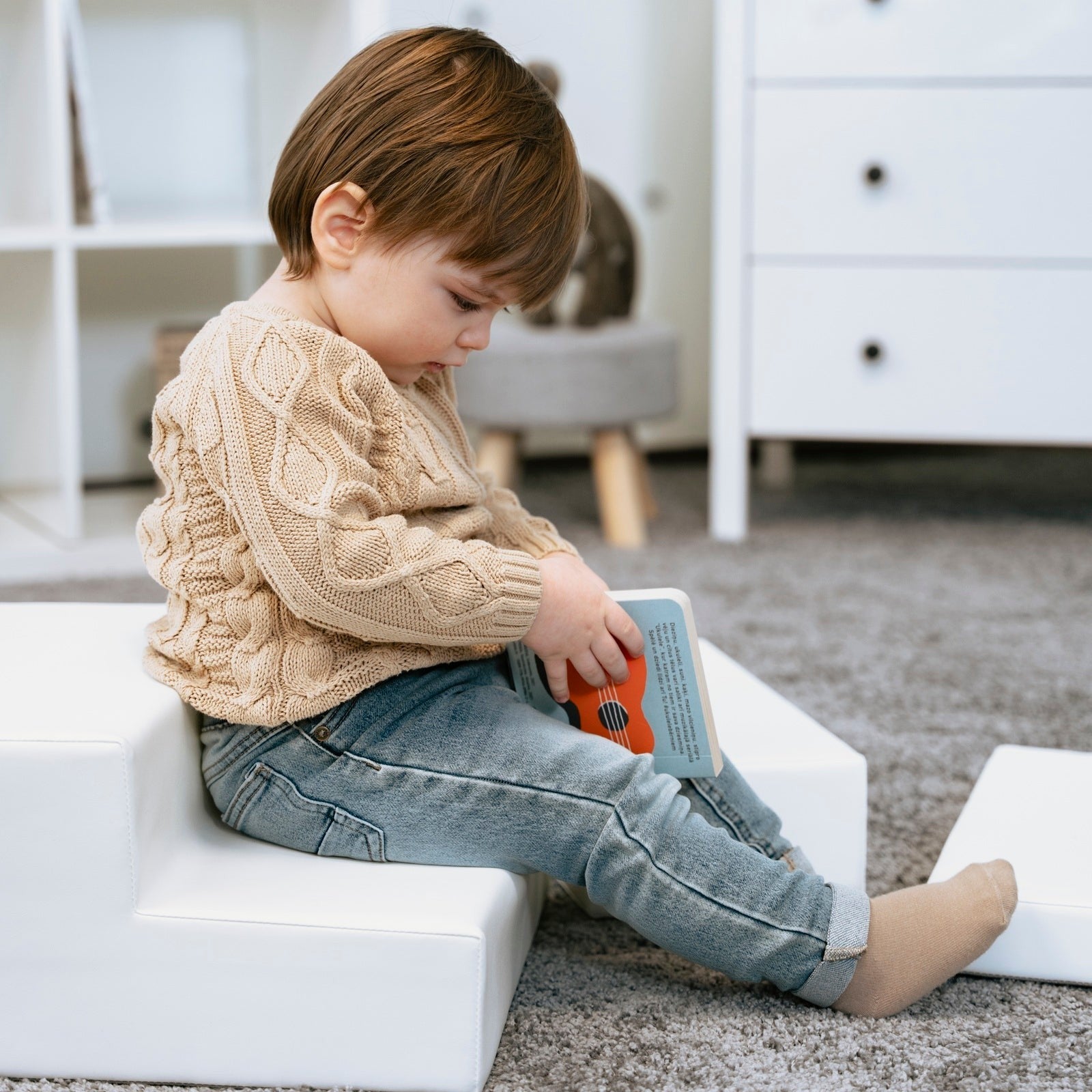 a toddler's hand reaching for the soft white corner climber foam block