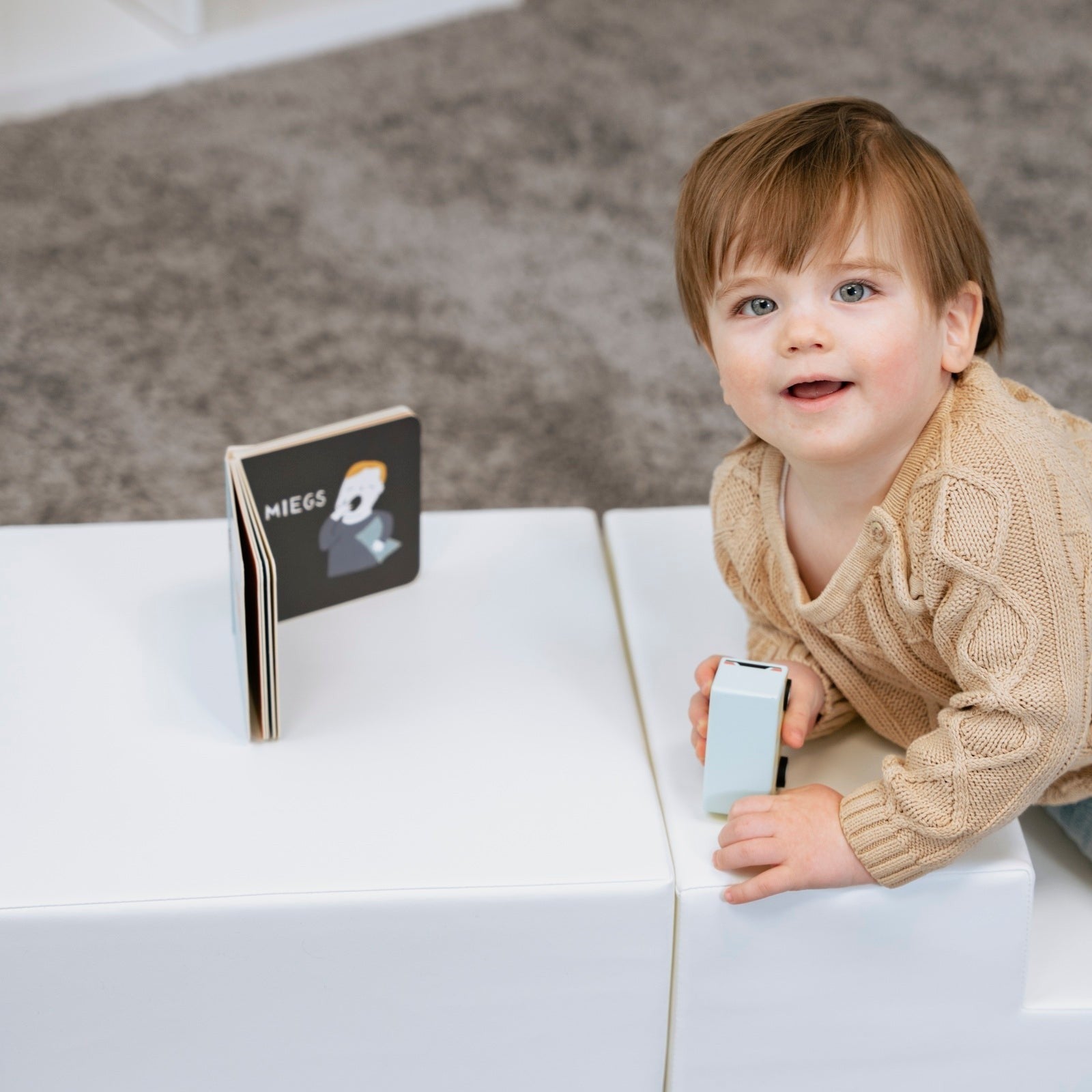 a toddler climbing on a soft white foam corner climber block set
