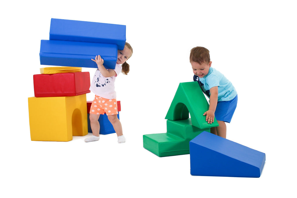 a child's hand stacking a vibrant iglu foam block on a sunlit playroom floor