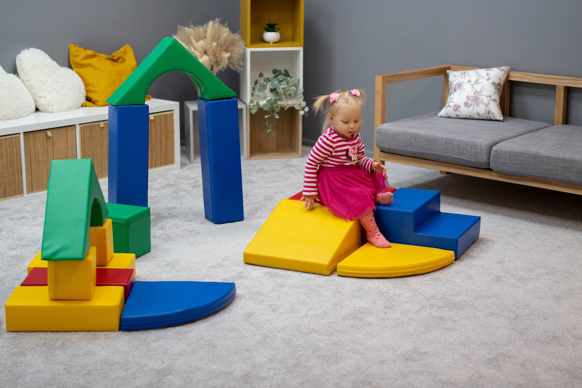 a soft multicolor foam block set arranged in a gentle arc on a cozy nursery rug