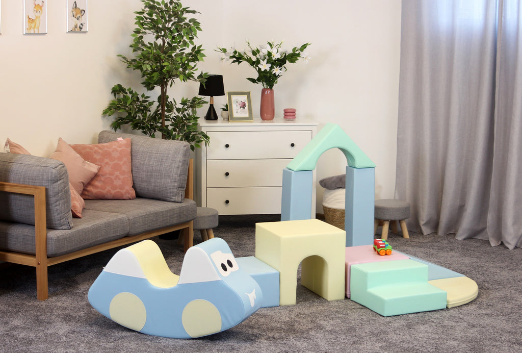 a child's hand stacking light pastel iglu foam blocks in a playful sunlit room