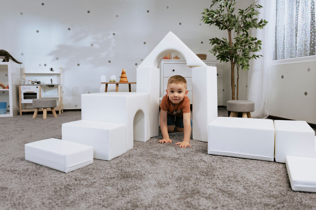 a child's hand placing the final white iglu foam block on a creative castle structure