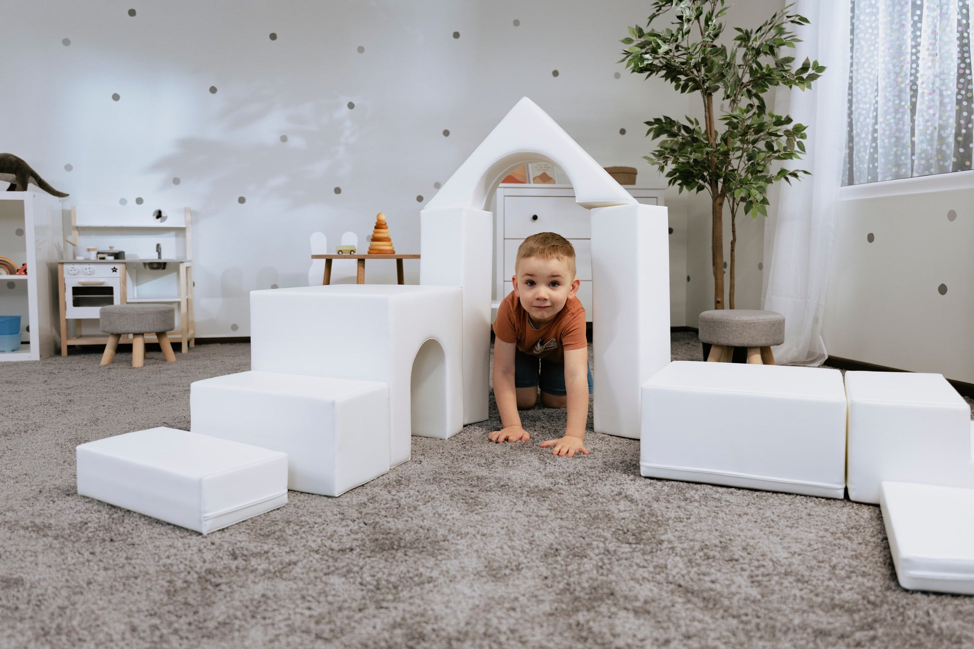 a child's hand placing the final white iglu foam block on a creative castle structure