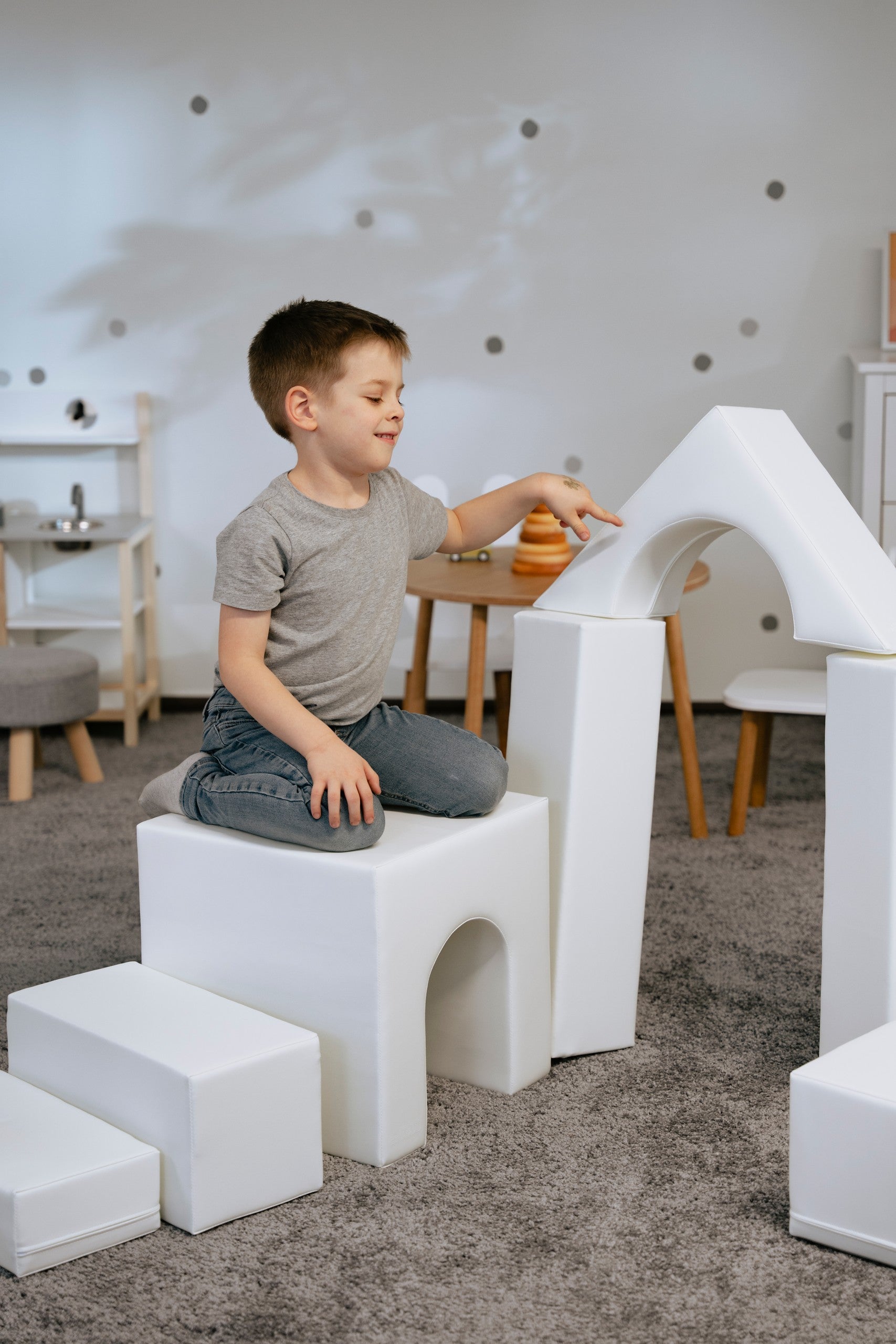 a child's hand placing a final white iglu foam block on a creative castle structure
