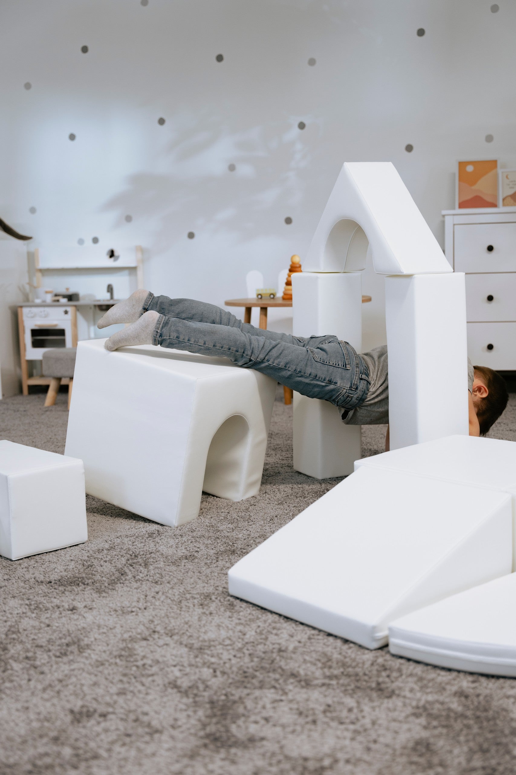 a toddler building a creative white iglu foam block castle in a sunlit playroom