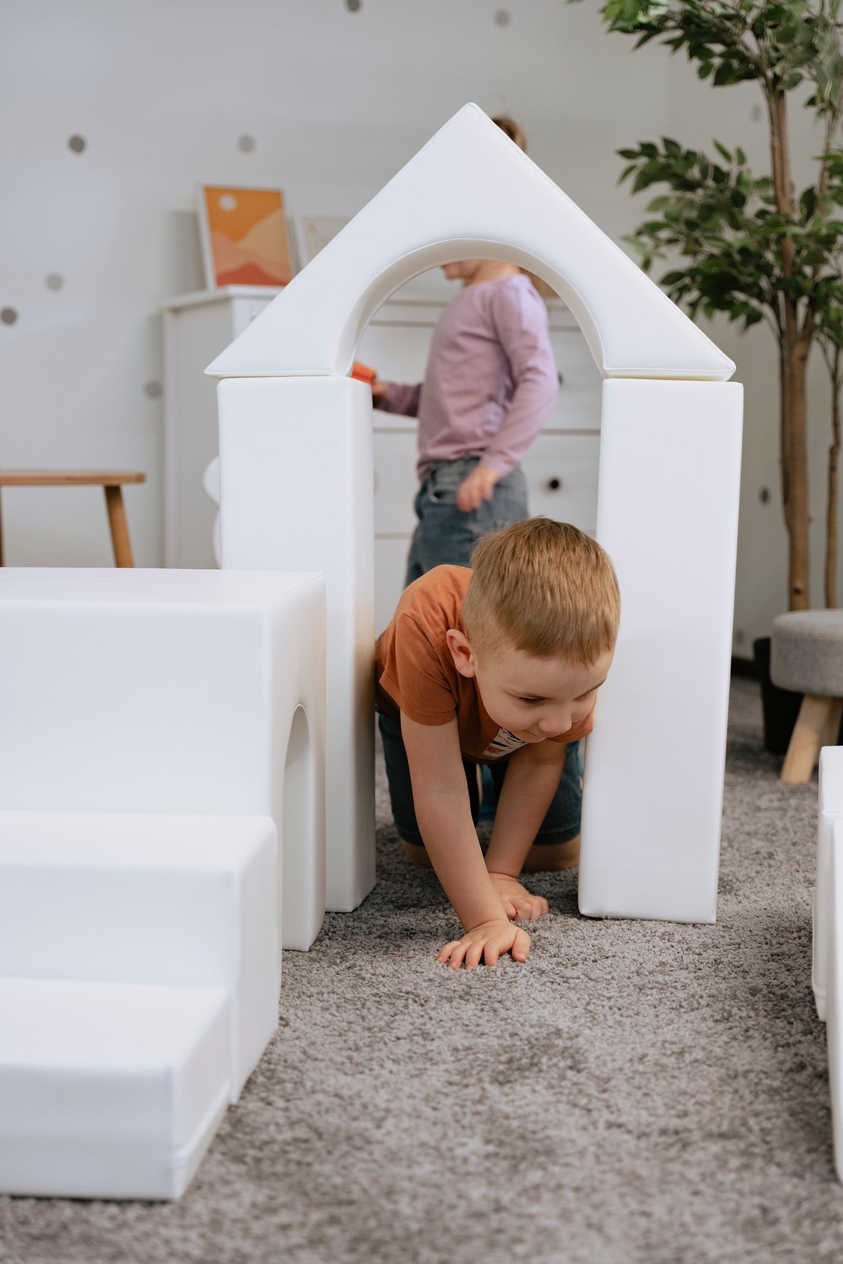 child building a creative white iglu foam block castle in a sunlit playroom